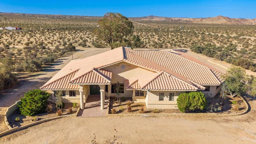 Enter this gated, fully fenced twenty-acre compound to find a stunning 3,077 sq ft home set on a cultivated jojoba farm. This 4-bedroom, 3-bath residence blends timeless charm with modern updates and is perfect for those seeking space, privacy, or unique income potential. Enter through a formal dining room with tasteful custom built-ins that leads into a beautiful den with a stylish step-down wet bar, perfect for entertaining. The great room showcases a striking stone fireplace, a secondary casual dining area, and an extra-large open kitchen with wood cabinetry, abundant storage, updated appliances, and elegant quartz counters. The primary suite is a true retreat on the west side of the home, featuring two walk-in closets and a beautifully updated bathroom with a freestanding soaking tub. The guest rooms are generously sized on the east side of the home, including a massive fourth bedroom that offers flexibility as a guest suite, studio, gym, or home office. Additional highlights include a large laundry room with plenty of storage and a huge attached four-car garage. Outside, you'll find ample flat, usable land to customize, expand, or simply soak in the serene desert surroundings. Whether you're seeking a desert sanctuary, investment property, family compound, or agricultural opportunity, this property delivers it all, with room to grow.