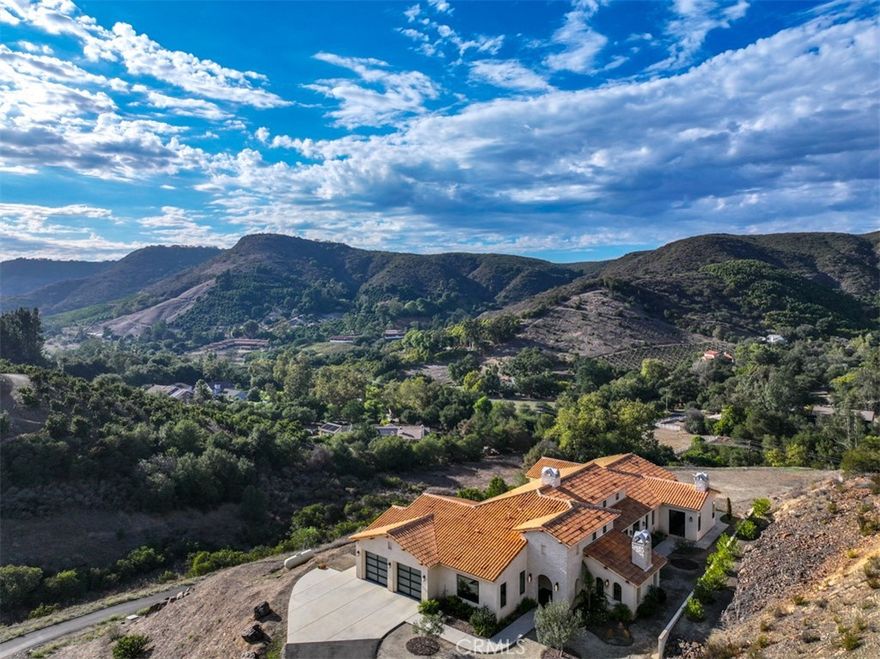Absolutely Stunning Blend of Andalusian and Modern Architecture! Welcome Home! Unique Blend of Enchanting Tradition and Elegant Contemporary Comforts will Surely Captivate Your Senses. This Timeless Beauty is Perched above De Luz Road, Offering Breathtaking Panoramic Views of the Surrounding Landscape from Almost Every Window and Every Patio. Must See this Modern Minimalist Design; Offering a Refreshing and Distinctive Character and a Perfect Spot for Relaxation and Entertaining. High-End Features Include Leicht Custom Kitchen, Three Heat & Glo Linear Fireplaces, 10 Foot Ceilings Throughout and 17 Foot Ceilings in Foyer and Gathering Room, Surround Sound Entertainment System with 75"Sony OLED with Apple TV in Family Room, Statuario Italian Porcelain in Kitchen and Baths, 30x30 Italian Tile Throughout, Glass Enclosed Wine Cellar, Miele M Touch Appliances, Miele Six Burner Gas Stove with Electric Oven, Dishwasher, Steam Oven and Espresso/Coffee, Light Touch Built-in Refrigerator/Freezer, Axor "Shower Heaven" in Primary Suite, California Closets Vertuoso Collection, Axor Faucets, Duravit Sinks and Wall Hung Toilets Throughout (In-wall units by Toto), All Interior Wall Insulated for energy efficiency and noise reduction,  2x6 Construction exterior and interior walls, Large Capacity Maytag Washer and Dryer, Two Navies Tankless Water Heaters, Two Seer 17 Cooling Systems with EcoBee Smart Thermostats, Outdoor Security Cameras and So Much More! Large Backyard is Ready for Your Ideas and Design and Over Eight Acres of Land is Ready for your Green Thumb! Just Minutes from Historic Old Town Temecula (EST. 1859) and Temecula Wine Country, World Class Golf, Casinos, Shopping, Dining and Excellent Schools. Must See!