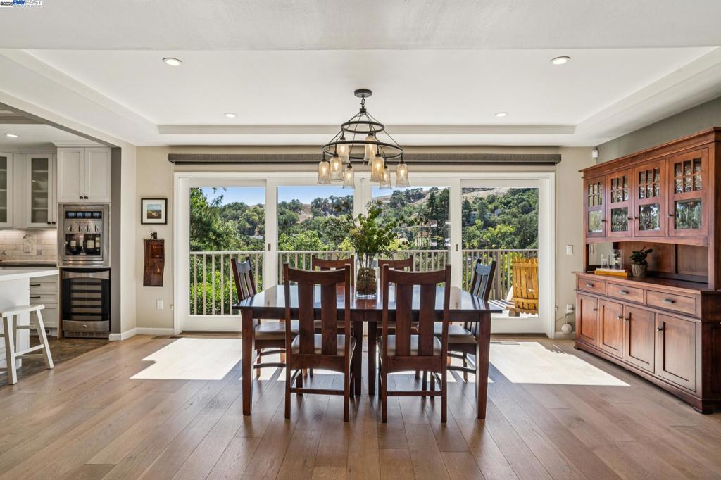 Welcome to this modern retreat with spectacular Burton Valley views, where refined design meets natural serenity. Floor-to-ceiling windows frame lush greenery and a spacious deck that seems to float above the valley. The open-concept main level centers around a designer kitchen with state-of-the-art appliances, a 48” dual-oven range with six burners, built-in four-bottle wine station, and walk-in pantry. The dining room opens to the deck for seamless indoor-outdoor entertaining, while the living room’s fireplace invites gathering amid tranquil views. This level also features a powder room, attached garage with an EV charger, and upstairs laundry closet. Off the kitchen, a private side-yard sanctuary offers a hot tub, outdoor shower, and a peaceful seating area. Three bedrooms and a remodeled bath with dual sinks, soaking tub, and shower complete the level. Downstairs, the primary suite has an elegant walk-in closet, an ensuite bathroom, and french doors opening to a lush yard with a patio and a large grassy area. Also included: an office, a second laundry room, a large storage area under the kitchen, and a 250+ bottle wine cellar. Fresh remodels throughout, owned solar, and move-in ready style complete this unforgettable home.