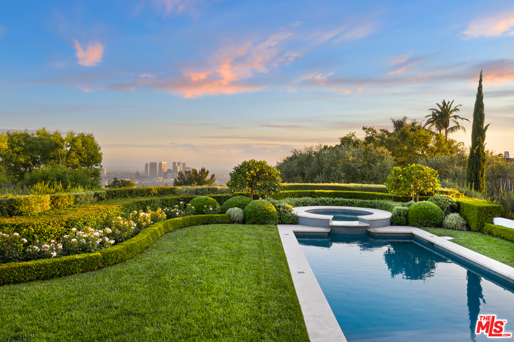 Situated on one of the few promontories in Beverly Hills, w/exceptional 360 degree city & ocean views, this architectural triumph rich in privacy offers the highest caliber of living in a world-class location. Privately secured behind gates, this home is impeccably built with the finest materials including bleached walnut wood & Balzac limestone floors. Soaring high ceilings paired w/custom steel casement floor-to-ceiling doors & windows flood the interior with an abundance of natural light. The gourmet chefs kitchen, w/professional appliances & oversized Sea Pearl Quartzite island, effortlessly flows into the glass & wood-paneled dining room overlooking the canyon. The master suite provides the ultimate escape, w/a cozy fireplace & sitting room leading to an expansive outdoor terrace w/270 degree views. The master bath completes this sanctuary-like suite w/white onyx dual vanities, heated silver travertine floors, a soaking tub, & two large connecting dressing rooms. Outside, resort-like grounds feature verdant landscaping and a sparkling pool & spa beautifully complemented by the substantial wraparound covered terraces, outdoor fireplace, and multiple seating & dining options. Equipped w/Control4 smart home technology, this home provides a seamless and luxurious lifestyle.