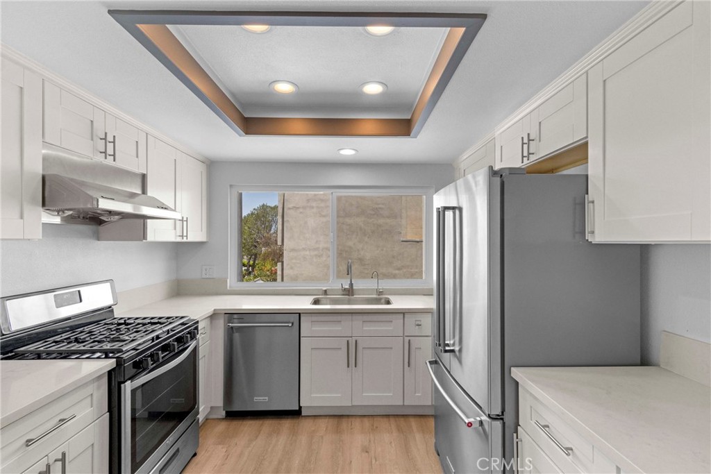 Experience modern elegance and effortless living in this fully remodeled 3-bedroom, 2-bathroom condo in the Mountain View Terrace community. From the moment you enter, you'll appreciate the attention to detail and quality finishes that make this home truly stand out. The designer kitchen is a showstopper—completely renovated with quartz countertops, stainless steel appliances (including refrigerator), custom soft-close cabinetry, and a reverse osmosis water filtration system. The open-concept family room flows seamlessly to a private balcony, creating an ideal space for relaxing or entertaining. The main-level primary suite offers a spacious walk-in closet with custom organization system, direct access to its own private balcony, and a beautifully upgraded ensuite bath with custom tile work in the shower, tile floors & quartz counters. The secondary bedrooms upstairs are generously sized, featuring mirrored closet doors and share a Jack-and-Jill bathroom also with quartz counters, tile floors and upgraded tile finishes. Stylish and functional, this home also features laminate flooring throughout, recessed lighting, dual-pane energy-efficient windows, plantation shutters, a Nest thermostat, Ring doorbell, and security cameras. Two large coat/storage closets on the main level offer additional space to keep you organized. Enjoy the convenience of an attached 2-car garage, in-garage laundry with washer and dryer included, and two additional assigned parking spaces. A security screen door allows for natural airflow while maintaining privacy. Located in a quiet, tree-lined community with ample guest parking and a sparkling community pool, this home offers the perfect blend of comfort, convenience, and style. Just minutes from schools, major freeways, shopping, restaurants, golf courses, and beautiful local parks. This is the Southern California living you've been looking for!