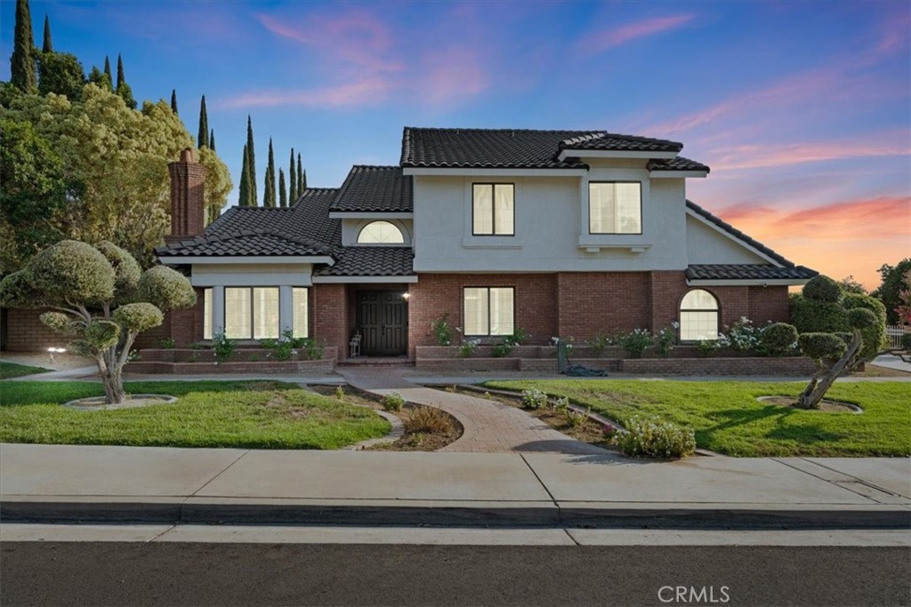 Welcome to Prestigious & Highly Desirable Hawarden Hills! This beautifully maintained two-story residence sits on nearly ¾ of an acre in a great location, offering timeless architecture, exceptional design, and ample space. From the moment you arrive, the striking curb appeal, mature landscaping, and expansive driveway with RV access set the tone for this impressive property. A double-door entry opens to a grand living room with soaring vaulted ceilings, custom shutters, cozy fireplace, and an adjoining formal dining room. A dramatic spiral staircase adds elegance, while the spacious family room showcases fine wood built-ins, a warm brick fireplace, wet bar, and recessed lighting. Multiple sliding doors create a seamless indoor-outdoor flow. The kitchen features picturesque backyard views, eat-in dining area, ceramic tile flooring, and a generous wraparound pantry with custom pull-out shelving—also found in the cabinetry for added convenience. With 4 bedrooms, plus a large bonus room and 3 bathrooms, the home offers flexibility for various lifestyles, including a main-floor bedroom and full bath ideal for guests or multi-generational living. Upstairs, the primary suite is a retreat with high ceilings, oak built-in headboard and desk (included), walk-in closet with organizer, and a spa-like bath with dual sinks, soaking tub, separate shower, and private water closet. A sliding door leads to a private balcony with peaceful backyard views. Additional updates include brand new carpet, fresh interior paint in most rooms, updated baths, custom shutters throughout, and smooth ceilings (popcorn removed). The expansive backyard is an entertainer’s dream—featuring a built-in BBQ, covered patio, storage shed, mature fruit trees, and endless space for gardening, play, or a future pool. A 3-car garage and prime location near shopping, dining, top-rated schools, and parks complete this exceptional offering. Hawarden Hills homes of this caliber are rare—don’t miss this opportunity!