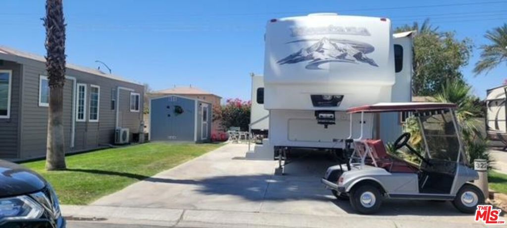 This property, on the west wall, is sold with a Montana 5th wheel that has been well maintained. The interior is deep woods and leather, with a great desk space, to keep your personal affairs in one place. There is an oversized shed, with a refrigerator and work bench, with double door entry, for easy use off of patio. The lot has a grass area adjacent to the patio space. The back wall, creates a semi private area, in the community. This all located in a 55+ community that has a 3 par golf course, chipping green, putting green, 9 hole mini golf, pickleball and tennis courts, bocce ball, an indoor shuffleboard courts, 2 clubhouses with pools and jacuzzies and an additional 4 satellites with pool, jacuzzies and mail boxes. This is all within a 24 hour gate guarded community of 801 lots, that consist of a combination of Park Models and RV lots, where you own the land. The resort has a limit of 270 day occupancy. It is a perfect place to spend your holidays in the sunshine.