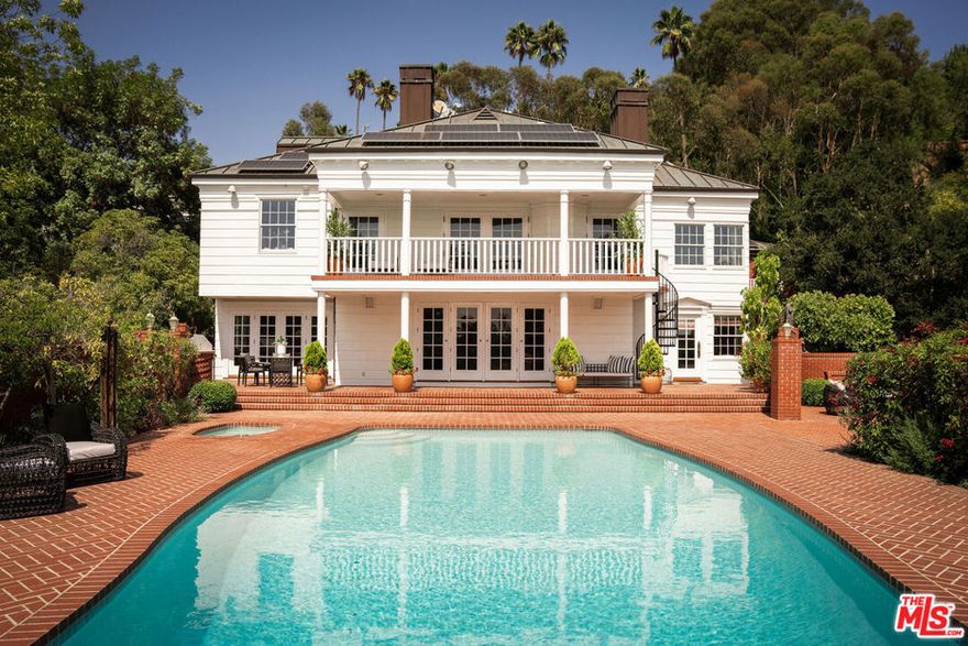 Set behind a stunning custom-designed gate and a long private drive, this Colonial-style Beverly Hills estate is gracefully surrounded by meticulous custom brickwork and pathways with one-of-a-kind designs. Resting on a nearly one-acre lot, the property balances timeless architecture with modern sophistication. Inside, the residence offers 6 bedrooms and 7 bathrooms along with exceptional amenities, including a screening/game room, gym, and a wine cellar concealed behind a secret door. At the heart of the home, a beautifully appointed kitchen with butcher block island and large walk-in pantry flows into a bright breakfast area, where French doors open to a tree-lined patio. A large dining room, ideal for entertaining and holiday gatherings, adds to the home's gracious scale. The formal living room opens through French doors directly to the swimmers pool and expansive patio, where canyon views create the perfect backdrop for outdoor dining and entertaining. The primary suite is a private sanctuary with a grand balcony overlooking the glistening pool and gardens, and even includes a hidden door to a spacious attic ideal for an art collection, studio, or private retreat. A distinguished office, finished in floor-to-ceiling custom cherry wood with a wet bar, offers both elegance and functionality. Outdoors, a custom built-in BBQ area anchors the resort-style grounds, complemented by lush landscaping, sparkling pool, expansive motor court, and custom brick pathways with unique designs. The collector's garage is a true showpiece, with space for six cars, a car lift for two, built-in tool stations, plus additional garage capacity for up to 10 more vehicles.Beyond its design pedigree, the estate also features a new 80-panel solar system with backup generator, a copper roof and copper plumbing, and comes with architectural plans for an additional 2,000-square-foot guest house a rare opportunity to expand on one of Benedict Canyon's most distinctive estates. Adding to its character, the property is also known for the iconic gorilla sculpture at the street front, a playful landmark that makes it instantly recognizable. Balancing privacy, scale, and sophistication, 1280 Benedict Canyon is a Beverly Hills Colonial estate of rare distinction, modern upgrades, and limitless potential.
