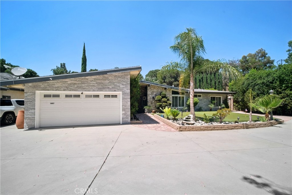 Welcome to 16857 Colven Rd, a beautifully upgraded and private Granada Hills retreat nestled on a rare 20,564 sq ft flag lot backing directly to the 14th tee box of Knollwood Country Club Golf Course. This 3-bedroom, 2.5-bathroom home offers approximately 2,516 sq ft of interior living space, with an additional 545+/- sq ft sunroom and 300+ sq ft pool house with bathroom—ideal as a guest retreat, studio, or flex space. Buyer to verify permit status and square footage.
Upgrades include vaulted ceilings, recessed lighting, tiled floors, Marvin Windows with Plantation Shutters, a 60' glass-enclosed sunroom, and a finished garage with insulation, drywall, and recessed lighting. A tankless water heater ensures comfort and efficiency, and a 2021 mini-split system provides zoned cooling. Paid-off solar panels (installed in 2015) offer long-term energy savings.
The property is accessed via a 160' private driveway leading to a sprawling ranch-style home. The front yard features custom lighting, fountains, ample parking, and a 320 sq. ft. 4-hole putting green. A custom wrought iron gate secures the front porch, blending curb appeal with peace of mind.
The remodeled kitchen boasts rich cabinetry, a two-level granite island, tile floors, a garden window, and recessed lighting. It opens to a spacious den, and a solid wood French door connects to the west patio. The sunroom features tinted windows, recessed lighting, and French doors on both sides, plus two 10’ Longview sliders and a 13’ Marvin wood-clad French door.
The primary suite offers tiled floors, recessed lighting, and a custom walk-in closet. The spa-style bathroom includes a stone accent wall, soaking tub, and a large shower enclosed with ¾” sapphire glass. Two additional bedrooms share a ¾ bath and feature mirrored closets, recessed lighting, ceiling fans, and mini-split AC.
The backyard is a true resort-style oasis with terraced landscaping, remodeled PebbleTec pool and spa, built-in BBQ and fire pit, basketball court, toddler playground, and private driving range. Fruit trees—including Meyer lemon, orange, grapefruit, and pomegranate—along with a cactus garden and Queen Palms complete the scene.
A rare opportunity to own a one-of-a-kind home on a premier lot with golf course access, quality upgrades, and lifestyle amenities.