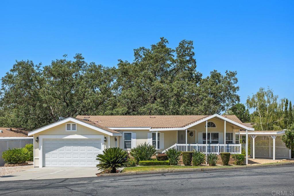 Welcome to Skyline Ranch Country Club, Valley Center’s premier 55+ golf course community. Situated on one of the best lots in the neighborhood, this beautiful 2-bedroom, 2-bath manufactured home offers 1,306 sq. ft. of comfortable living space. Built in 2005, this home features an open concept floor plan where the kitchen, dining and living areas all flow seamlessly together – ideal for entertaining guests! Other features include a den which could be an optional 3rd bedroom or office, a newer roof, newer flooring, ceiling fans in the living room, den, and bedrooms, and a full-size laundry room. There is an abundance of parking including a 2 car garage, a driveway where you can park 2 more cars, a carport for parking yet another vehicle, as well as a covered parking spot for the golf cart, which is included with the home! Looking for storage? This home has it! There is built-in shelving in the garage plus a separate shed adjacent to the golf cart carport. This home has tremendous curb appeal thanks to meticulous landscaping and an inviting covered front porch with spectacular views of the community pond and golf course. The serene, fully fenced backyard features several fruit trees including lemon, grapefruit and green apple, and a patio area surrounded by natural rock formations shaded by one of the most beautiful oak trees you will ever see. The $1,600/month space rent covers access to incredible community amenities, including unlimited golf, 2 pools, spa, clubhouse, dog park, fitness center, and available RV/boat storage for a nominal fee. This home offers the perfect blend of privacy and active living—don’t miss your chance to enjoy the Skyline Ranch lifestyle!