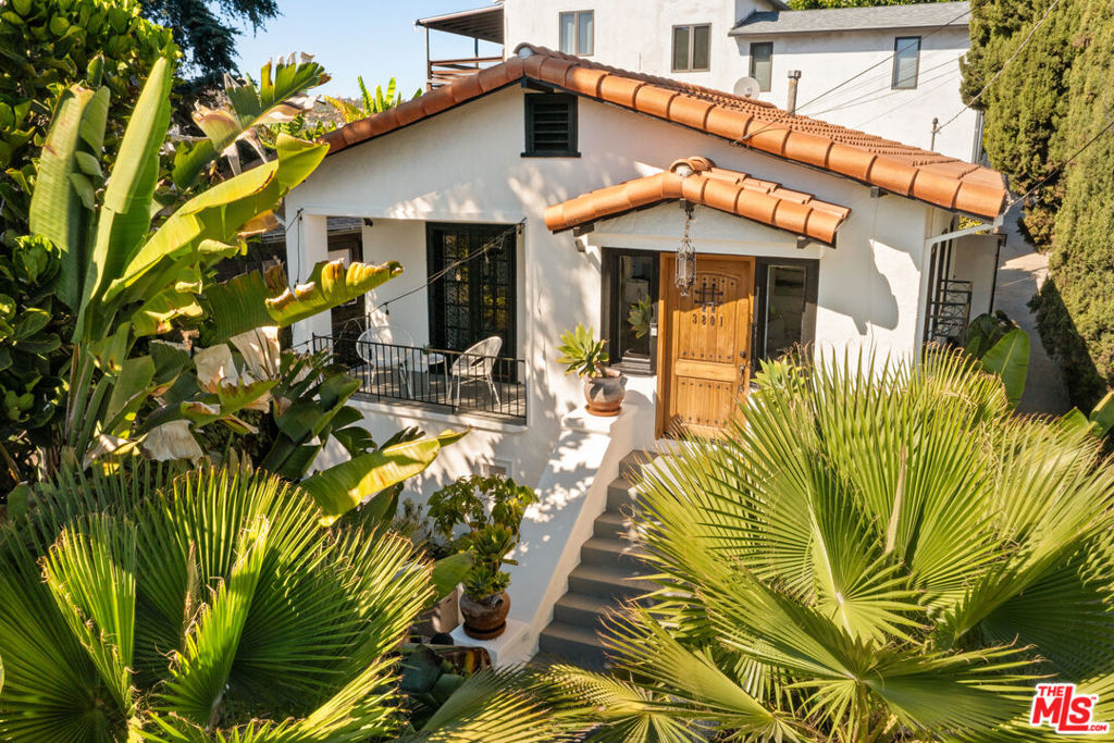 Perched on a sunlit corner lot in the heart of Sunset Junction, this enchanting 1920's Spanish bungalow offers the perfect blend of historic charm and modern living. Just two blocks from Sunset Boulevard, the home captures sweeping views of Downtown Los Angeles and the Hollywood Hills, creating a backdrop as vibrant as the neighborhood itself. Step inside to discover refinished original hardwood floors, a living room adorned with a decorative Batchelder-tiled fireplace, and seamless flow into the dining area and kitchen. The kitchen shines with quartz countertops, stainless steel appliances, and built-in cabinetry, while a private balcony invites you to savor the lush surroundings and city views. The serene bedroom offers two spacious walk-in closets with custom built-ins and a newly updated en-suite bath. Modern comforts abound with smart home features, mini splits for year-round comfort, and an LG washer/dryer. Outside, a courtyard with twinkling string lights and lush landscaping creates a magical setting for dining and lounging, while a gated driveway with a quaint adjacent seating area adds privacy and convenience. Perfectly positioned within walking distance to the Silver Lake Farmers Market and acclaimed local favorites including Pine & Crane, Tartine, The Black Cat, and Millie's Cafe this home offers an unmatched lifestyle in one of LA's most coveted neighborhoods. Whether you're seeking a private retreat, an entertainer's dream, or simply a rare piece of Silver Lake history, 3801 Effie Street is an opportunity not to be missed.
