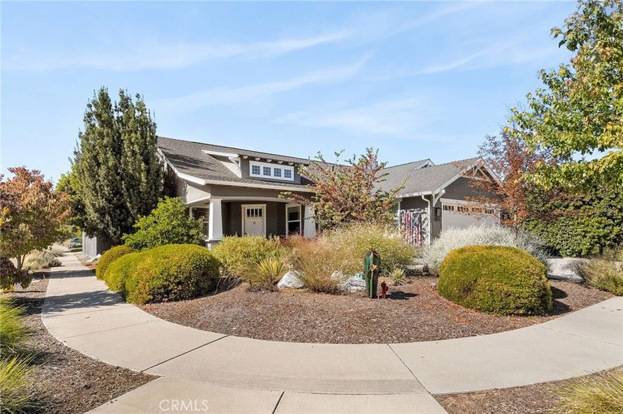Tucked among the orchards on Chico’s quiet west side, 1924 Waxwing Way is more than a home; it’s an experience. A place where refined craftsmanship meets everyday comfort, and thoughtful design invites you to slow down, breathe, and truly live. Built by Shastan Homes and gracefully set on a corner lot, this 4-bedroom, 2.5-bath residence spans over 2,500 sq. ft., blending modern elegance with timeless charm. From the moment you arrive, you’ll be captivated by the curb appeal, the welcoming front porch, newly stained fencing, and drought-tolerant landscaping framed by mature greenery. Step inside and feel the harmony of space and light. The entry opens to tray ceilings, luxury vinyl plank flooring, and designer fixtures that draw you toward the heart of the home. Just off the entry, a cozy family room sets the tone for gatherings, a perfect spot to greet guests or enjoy morning coffee as sunlight fills the space. The layout flows effortlessly, offering places for connection and retreat. A dedicated movie room with French doors is ideal for a quiet night in, while the open-concept living room and kitchen are made for togetherness. Tray ceilings, recessed lighting, and large windows bring warmth and natural light to every corner. The kitchen is both functional and beautiful, anchored by granite countertops, bar seating, and a cabinet pantry. Brand-new stainless steel double ovens, cooktop, and microwave shine beneath updated fixtures. Designer hardware, a wet bar, and custom up-down shades throughout add elegance that elevates every moment, whether hosting friends or enjoying a quiet dinner at home. The primary suite is a true retreat, privately tucked away with vaulted, beamed ceilings, a window seat overlooking the backyard, and two walk-in closets for easy organization. The ensuite bath rivals any spa with a deep soaking tub, dual sinks, and a tiled walk-in shower designed to wash the day away. Outside, the backyard feels like a private resort, complete with a saltwater pool, island seating, attached Jacuzzi, pergola with ceiling fans, and lush landscaping dotted with Meyer lemon and orange trees. Every corner invites relaxation year-round. Additional highlights include a Nest thermostat, whole-house fan, new designer hardware, updated interior fans, and top-of-the-line automated designer toilets for an unexpected touch of everyday luxury. 1924 Waxwing Way isn’t just a home—it’s a refined expression of luxury, craftsmanship, and California living.