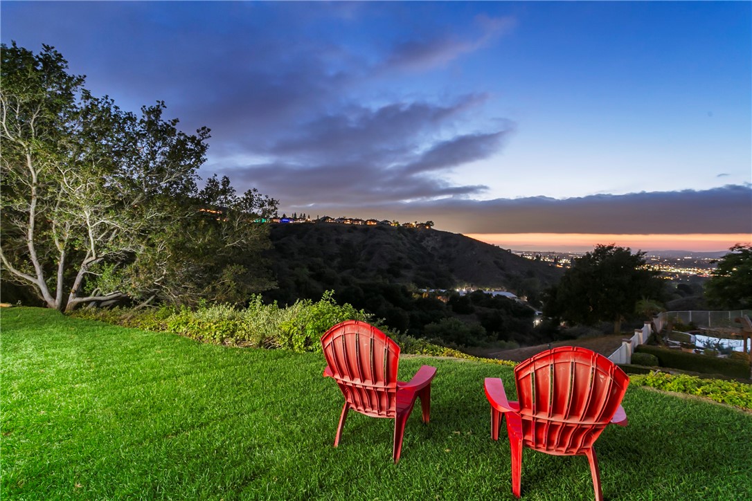 This one is special. Nestled on a peaceful, secluded lot in Anaheim Hills, high in the hills and surrounded by nature, this beautifully remodeled 2-story home offers unmatched tranquility and breathtaking views. Numerous large picture-windows provide abundant natural light and spectacular city-light and mountain views from the living room, dining room, kitchen and backyard. High ceilings in the fireside living room offer that large, open feel. The backyard is spacious, private, and peaceful, perfect for outdoor relaxing and entertaining. Spacious bedrooms. Inside laundry. Attached three-car garage. A previous downstairs bedroom can easily be converted back. Downstairs bathroom with shower. Community pool, clubhouse and tennis courts. Great schools. Complete remodel throughout including new kitchen with premium appliances, bathrooms, windows & sliders and roof. Close to golf, parks, entertainment, restaurants, shopping, Nature Center, Saddle Club and hiking trails. Quiet neighborhoods, beautiful hills and a constant breeze all provide that feeling of being away from it all while still being close to so much. A truly wonderful place to live.
