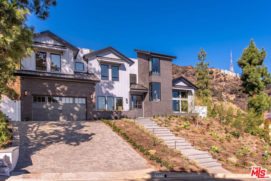 SPECTACULAR NEW CONSTRUCTION! Modern farmhouse under the Hollywood sign at the top of Lake Hollywood Estates. 5 en-suite bdrms, LR with fireplace; DR with wine wall, all with vaulted ceilings. Master has private terrace w/ direct view of the Hollywood sign,enormous walk-in closet, fpl and over sized bathroom. Open floor plan kitchen and family room with fpl warm the heart of the house & open to outdoor dining area for indoor/outdoor living. Kitchen has 2 islands one for meal prep; one for dining, plus huge walk-in pantry perfect for your countertop appliances w/ additional counter space, Thermador appliances thru out kitchen. Screening room, formal LR, outdoor kitchen and dining area poolside plus cabana en-suite, spa, firepit and BBQ. This is the ultimate entertainers home! House backs to private vineyard on hillside beyond property, complete privacy for the outdoor areas. VIEWS of Lake Hollywood from roofdeck. Video in property website