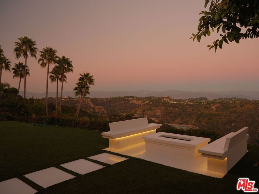 Perched in the hills of Bel Air, 2262 Stradella Road represents a striking revival of architect J.R. Davidson's mid-century vision. First completed in 1958, the residence has been reimagined through a two-year restoration that honors its original character while layering in modern materials, design elements, and smart-home technology. Expansive glass walls dissolve the boundary between indoors and outdoors, showcasing sweeping views of Stone Canyon Reservoir, the Santa MonicaMountains, and the city skyline.Inside, terrazzo floors flow seamlessly through the home, offset by custom wood cabinetry and exposed beams that emphasize its architectural pedigree. The galley-style kitchen equipped with premier appliances and handcrafted cabinetry opens to a dramatic outdoor pavilion designed for all-season entertaining. Retractable glass walls, a fully outfitted second kitchen, and built-in heating create a true extension of the home.The primary suite is secluded for privacy and framed by uninterrupted views, while the spa-inspired baths feature floating slab vanities, switch-glass privacy systems, an infrared sauna, and even a cryo-therapy chamber. Outdoors, approximately 1,400 sq. ft. of living space is devoted to relaxation and entertaining, with integrated sound and media systems. A temperature-controlled reflecting pond anchors the grounds, complemented by a private putting green and fire pit perfectly oriented for jetliner views.Plans, soils, and surveys are in place for the addition of an infinity-edge lap pool and ADU, offering future potential for an even more elevated lifestyle