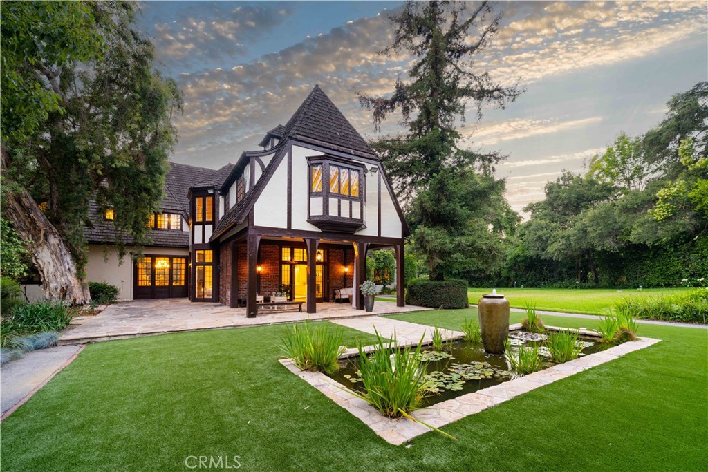 Welcome to one of Pasadena’s most extraordinary legacy properties, an architectural masterpiece blending historic English Arts & Crafts design with thoughtful modern updates, nestled on over 3.5 acres of flat and gated grounds in the prestigious South Arroyo neighborhood of SW Pasadena.
Originally built in 1915 by renowned architect Stiles O. Clements who designed the Hollywood Park Racetrack and Beverly Hills High School, this grand English Revival estate, also known as the Chandler House, was later expanded in 1931 by Kenneth A. Gordon and served as the 50th Annual Pasadena Showcase House of Design in 2014.
With nearly 12,000 square feet of combined living space, including close to 10,000 square feet in the main residence and nearly 1,300 square feet in the restored two-story carriage house, this estate offers both grand scale and architectural integrity. The home underwent a meticulous, top-to-bottom restoration in 2021–2022, blending timeless craftsmanship with modern comfort and convenience. Inside the main house, the signature architectural details include a 25x40 redwood-paneled Great Room with hand-hewn beams, leaded glass windows, a massive fireplace, and oak floors. The home features 6 bedrooms and 7 bathrooms, with 4 en-suite bedrooms upstairs, as well as cozy family spaces, a TV lounge, a spacious laundry room, and a remodeled third-floor flex space. A stunning modern kitchen with Viking appliances, a breakfast area, and an adjacent formal dining room providing an excellent space for hosting gatherings, celebrations, and memorable holiday parties. The re-designed wine cellar and tasting room on the lower level are perfect for hosting in style. Beyond the main residence, the beautifully restored two-story carriage house comes equipped with a guest room, bathroom, kitchenette, sitting area and it’s own private entrance.
Step outside into a private botanical paradise. including a pool with bathhouse, outdoor kitchen with BBQ and sound system, lily pond with water fountain, rose garden, and much more. a rare spring-fed well system updated in 2022 that supplies irrigation through three holding tanks.
This is more than a home, it’s a private retreat with a rich legacy, conveniently located close to the Rose Bowl, San Rafael Bridge, DTLA and minutes from all Pasadena has to offer. A Rare Opportunity to own a timeless estate of scale, privacy, and provenance, beautifully preserved and ready to begin its next chapter.