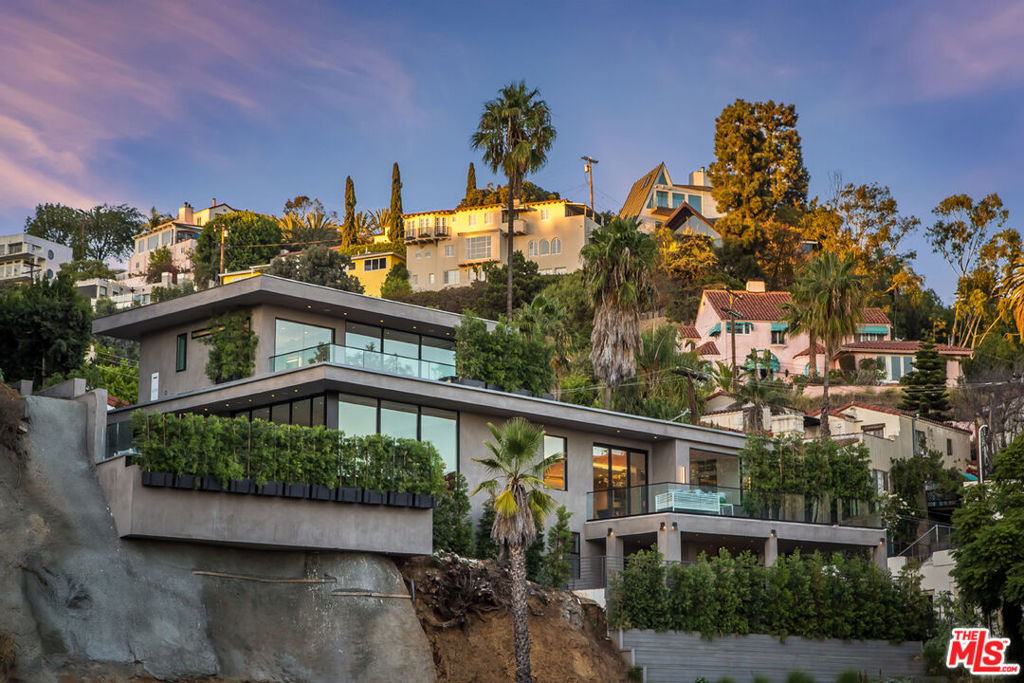 An exquisitely crafted contemporary on the Sunset Strip with expansive views of the city lights. More than 4,200 sq. ft. of refined interior living boasting exceptional finishes throughout. An open floor plan with chefs kitchen, a dramatic floor-to-ceiling fireplace separating the dining and living areas, and sliding glass doors opening to an expansive yard with infinity pool, firepit, and BBQ with outdoor eating area. The owner's bedroom overlooks the Sunset Strip and city lights, with a terrace, walk-in closet, and spa-like bathroom. Three additional guest bedrooms include en-suite bathrooms and access to a large shaded terrace.