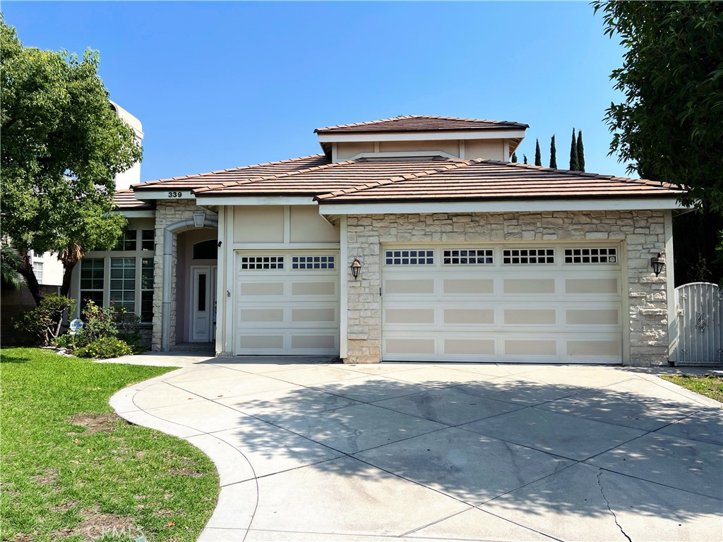 Located in the highly desirable Highland Oaks neighborhood of Arcadia, 339 E Floral Avenue is a beautifully maintained south-facing Mur-Sol custom home built in 1997. Offering approximately 3,155 square feet of elegant living space on a 7,535 square foot lot, this residence features 5 bedrooms and 3.5 bathrooms, including two main-level bedrooms ideal for guests or multi-generational living. The formal living and dining rooms boast soaring ceilings, marble floors, decorative columns, a chandelier, and a cozy fireplace, creating a grand yet welcoming atmosphere. The gourmet kitchen is equipped with granite countertops, a breakfast bar, stainless steel appliances, and a bright bay-window breakfast nook. The spacious family room includes hardwood floors, crown molding, built-in shelves, a wet bar, and sliding glass doors that lead to the serene backyard—perfect for relaxing or entertaining. The luxurious master suite features dual sinks, a soaking tub, separate shower, and a walk-in closet. Additional highlights include an indoor laundry room, a 3-car attached garage, and dual-zone central air and heating. The home is conveniently located near the 210 freeway, supermarkets, restaurants, and is within walking distance to top-rated Arcadia schools including Foothills Middle School and Highland Oaks Elementary. This is a rare opportunity to lease a move-in ready home in one of Arcadia’s most sought-after neighborhoods.