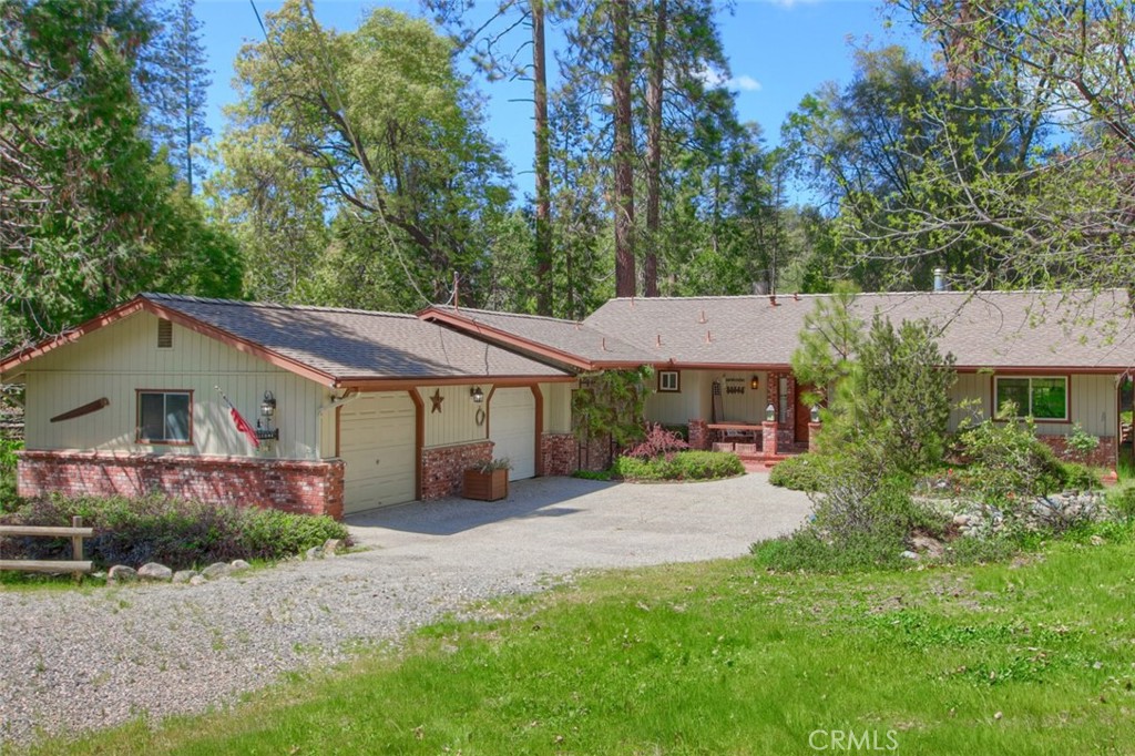 Fully furnished popular vacation rental with a peaceful setting and charming atmosphere! This 3 bedroom, 2 bath home sits on 1.22+/- acres where you can enjoy the cooler summer temperatures. Feel like you are on a retreat every day with a private spa, covered porches in the front and back, cozy window seat for reading a book or just enjoy the view, a seasonal creek, and beautiful trees. From the spacious front entry you can head into the living room, kitchen or dining area. The living room has great views, a fireplace with insert, built-in bookcase and a window seat. The dining area has a large picture window to enjoy the view and is perfect for entertaining your friends and family. Tile counter space galore, recessed lighting, tin tiled ceiling and stainless steel appliances including a built-in stove top, built-in ovens, dishwasher and refrigerator. The primary bedroom is huge and has a private fireplace, private entrance to the porch, a walk-in closet and the adjoining bathroom with double vanities and shower/tub. The smaller guest bedroom also has a private entrance to the porch or deck. The larger guest bedroom has built-in cabinets, potential wet bar with sink and a private entrance to the outside. Laundry set-up in conveniently in the hall closet. Enjoy the covered deck to sit a listen for birds or just watch for wildlife to scamper by. Take a relaxing soak in the private spa and you'll see why this home is a popular vacation rental! The rustic beauty is all round you with tall trees, quaint waterfall feature and landscaping. There is a 2 car garage with a pool table included and a storage shed. Close to Yosemite National Park for one of a kind beauty, Mariposa for historic sites, Oakhurst for shopping or Bass Lake for water fun! Come and see this charming home today!