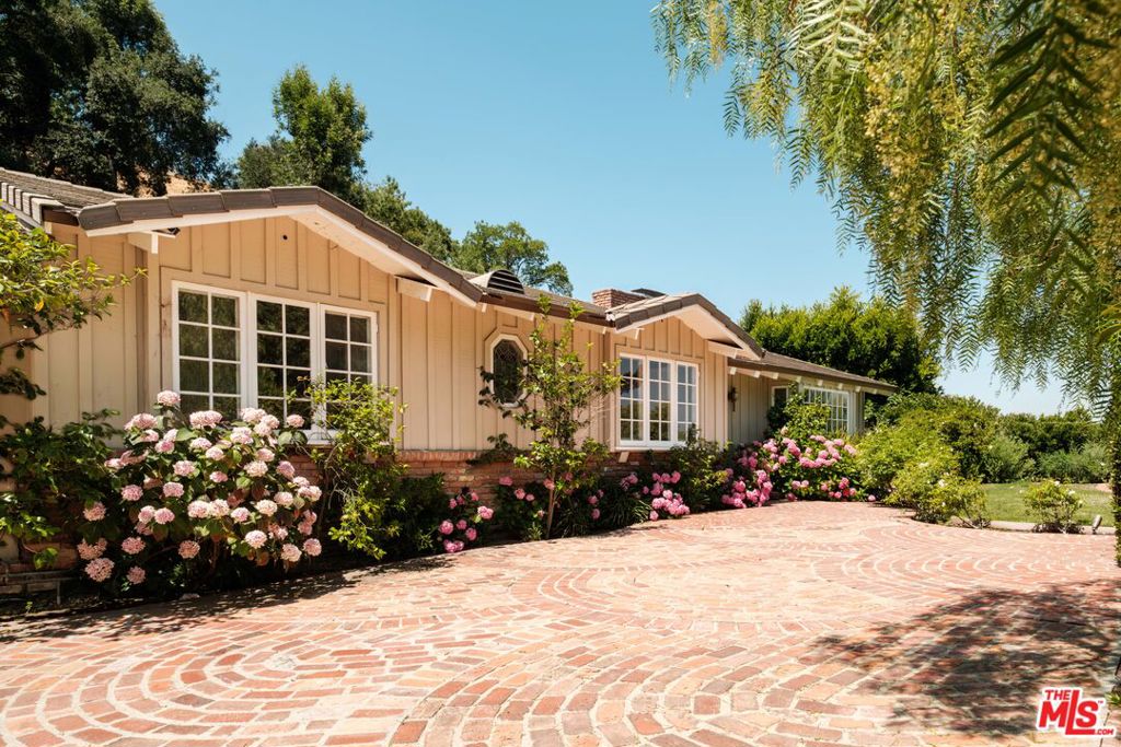 First time on the market in over 50 years! Welcome to this storybook California Ranch-style home, set back from the street with a brick driveway that enhances its timeless curb appeal. Framed by flourishing hydrangeas and lush greenery, the home exudes classic character and warmth throughout. Inside, you'll find three spacious bedrooms, two bathrooms, and sun-drenched living spaces designed for comfort and connection. The living and den areas are seamlessly connected by a charming dual-sided fireplace and feature wood-beamed ceilings that infuse the space with rich character and architectural appeal. The kitchen offers picturesque views of the beautifully landscaped yard and features a built-in counter for casual seating, perfect for enjoying a morning coffee or embracing the easy indoor-outdoor lifestyle. French doors open to a private backyard retreat with a sparkling pool and spa, ideal for relaxing, entertaining, and making the most of sunny California days. Set on an expansive lot with a covered garage, the property presents a rare opportunity to enjoy as-is or add your personal touch over time. A special offering filled with soul, space, and potential ready to be cherished by its next owner.