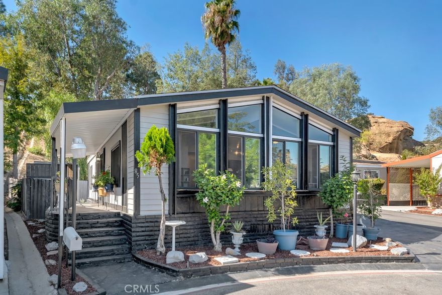 Located on a private cul-de-sac in an all-ages community, this light and bright home offers stunning views and modern comfort. Features include an open floorplan with vaulted ceilings, updated double pane windows, granite kitchen countertops, and a spacious en-suite primary bedroom with walk-in closet. Enjoy outdoor living with a covered front patio, fenced backyard, and large wraparound patio—perfect for entertaining. Extras include a separate laundry room, oversized shed, and covered carport for up to three autos. Community amenities: pool, jacuzzi, sauna, clubhouse, meeting room, picnic area, and common RV storage. Park approval required for land lease.