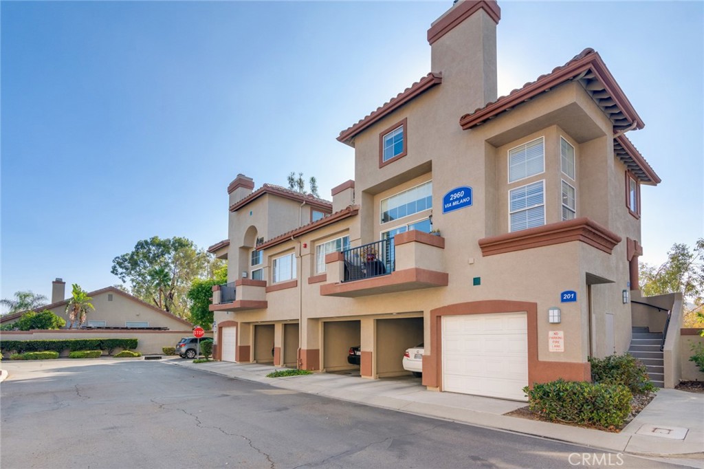 Welcome to this beautiful corner-unit condominium in the highly desirable Villaggio community. This two-bedroom home offers a spacious and open floor plan with custom flooring throughout. The inviting living room features a cozy fireplace and flows seamlessly into the dining area and kitchen, where you'll find custom cabinetry, sleek marble countertops, and stainless steel appliances. The dining area opens to a balcony, perfect for morning coffee or evening relaxation. The main floor bedroom boasts a walk-in closet and an upgraded bathroom complete with dual sinks and travertine flooring. A convenient laundry closet with built-in cabinets is also located on the main level. Upstairs, you'll find a spacious loft-style room currently being used as an office, along with a secondary bedroom featuring a charming pocket door entry, walk-in closet, and a beautiful built-in storage area with a window seat. Motorized blinds and second private balcony enhance the upstairs living spaces, while the upgraded bathroom offers a barn door entry and custom walk-in shower. Additional highlights include a one-car garage directly below the unit, community amenities such as a sparking pool, spa and beautifully maintained landscaping. Ideally located near shopping, dining, and with easy access to the 91 and 15 freeways, this home offers both comfort and convenience.