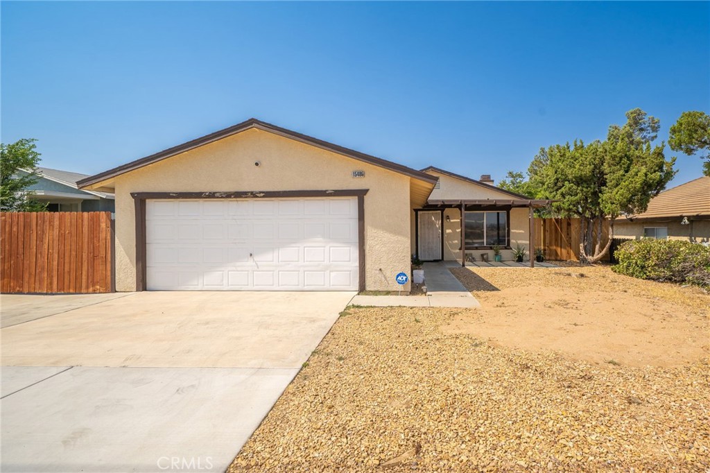 Welcome Home! This 3-bedroom, 2-bathroom, 1,257 sq ft single-story house blends classic charm with modern conveniences in a family-friendly Victorville neighborhood. Enjoy central A/C, energy-efficient double-pane windows, and an open-concept layout that keeps everyone connected in comfort year-round. Vaulted ceilings and a cozy gas fireplace create a warm, open ambiance in the living room. The space flows seamlessly into the dining area and kitchen, perfect for entertaining. Home chefs will love the kitchen’s sleek granite countertops and ample cabinet space. Down the hall, three comfortable bedrooms offer a peaceful retreat. The primary suite boasts its own en-suite bathroom and a walk-in closet, while the two additional bedrooms share a clean, well-appointed second full bath with a convenient tub/shower combination. Outside, the property provides a private haven without heavy upkeep. The front yard features neat, low-maintenance rock landscaping, and a welcoming covered front porch – ideal for morning coffee or chatting with neighbors. A side yard with green artificial turf adds splash of color and is perfect for play or pets. An enclosed side patio offers a weather-protected space for year round enjoyment. Imagine an outdoor dining area, playroom, or home gym. The fully fenced yard is ready for barbecues and family gatherings under the clear desert sky. Parking is a breeze with an attached oversized two-car garage (complete with custom storage cabinets) and an expanded driveway with a double gate for extra vehicles or even RV access.
Located on a quiet street in an established community, this home is minutes from I-15, making commutes or weekend getaways easy. Families will appreciate the nearby quality schools (like Del Rey Elementary and Lakeview Leadership Academy). Shopping, dining, and entertainment are close at hand. From grocery stores to the Mall of Victor Valley. With local parks, playgrounds, golf courses, and community events just a short drive away, there’s always something fun for everyone near your doorstep. Don’t miss out on this delightful Victorville home that truly has it all; Comfort, convenience, and charm!