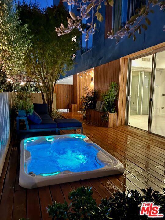 ***Priced strategically to sell quickly.*** Appraisal performed 6/2025 with $1.47M valuation, attached to listing. Highly desirable ground-floor garden residence in starchitect Zoltan Pali's iconic "Blue Velvet" building. This former model unit offers 2 bedrooms and 2.5 baths and delivers a level of indoor-outdoor living that is almost impossible to find in the city. A massive 400+ square foot private veranda spans the full width of the home, creating a seamless extension of the living space and making it perfect for entertaining, dining al fresco, relaxing with morning coffee, or unwinding in the included Hot Spring saltwater spa per seller, the only permitted spa in the building. Priced strategically below a recent closed comparable in the building (#104 at$1.47M), this home offers exceptional value for one of the area's most sought-after architectural residences. Inside you'll find soaring ceilings, oversized walk-in closets, and two luxurious en-suite bedrooms. Designer upgrades total more than $100,000 and include a Miele built-in coffee system, steam oven, and microwave drawer, a professional-grade Bertazzoni range, a Thermador built-in refrigerator, custom Italian cabinetry with upgraded glass fronts, Caesarstone countertops, rain shower,jet tub, and digital shower controls, custom Closet World organizers in both suites, Philips Hue smart lighting with added recessed lights, EV charging station, upgraded outlets and switches, and in-unit laundry hookups. A powder room for guests is conveniently located off the main living space. The building offers controlled access, two gated parking spaces, a large private storage unit, and a resident-only rooftop sundeck and reading lounge. Perfectly positioned just off Santa Monica Boulevard in the heart of the West Hollywood lifestyle, with a Walk Score of 88, this home is steps from Melrose Place, renowned restaurants, boutique shopping, high-energy nightlife, trendy coffee spots, gyms, and the Sunday Farmers Market. Optional patio furniture and bar may be included at no additional cost.