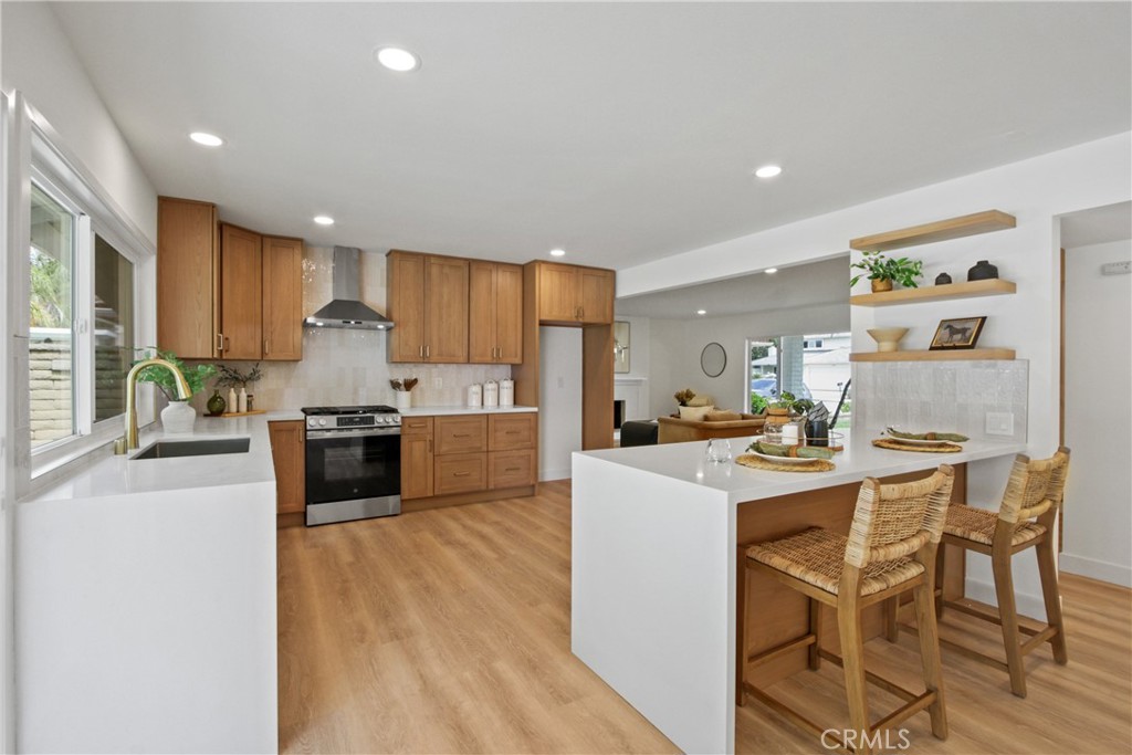 Reflecting today’s preferred aesthetic through an all-embracing and exquisitely crafted remodel, this generously sized home in Mission Viejo’s desirable Aegean Hills neighborhood is now a showplace for modern living and timeless design. Curb appeal is undeniable, with a classic white exterior, a covered entrance and graceful shade tree that create a welcoming scene. Double doors lead the way to a two-story interior that measures approximately 2,582 square feet. Five spacious bedrooms and three full baths cater to various lifestyles and multi-generational living, with a bedroom and full bath on the main floor. Entertain graciously in a formal living room with a large picture window and a formal dining room that opens to the backyard. Venetian plaster distinguishes the custom living room fireplace and another in the family room. Flowing freely to the family and formal rooms, the home’s reimagined open-concept kitchen is enhanced with waterfall-edge quartz countertops, a peninsula bar with seating, a wine refrigerator, soft-close wood Shaker cabinetry, open shelving, full tile backsplash and new stainless steel appliances. Two large sliders open the family and kitchen area to an ample backyard with mature trees, new landscaping and fencing, and a shaded patio space. Nearly 7,370 square feet, the homesite overlooks a neighborhood park. Baths are appointed with contemporary designer tile, upgraded vanities and mirrors, satin-finished brass plumbing and lighting fixtures, and in the secondary bathroom located upstairs, gorgeous marble flooring. Custom built-ins are showcased in the second floor’s open hallway, which leads to an inviting primary suite where a walk-in closet includes a custom built-in storage system, and the ensuite bath shines with gorgeous on-trend tile, marble finishes, a freestanding tub, dual-head walk-in shower and two sinks. Wide luxury vinyl plank flooring, lux carpet in bedrooms, ceiling fans, fresh exterior paint, a new energy-saving HVAC system, an interior laundry room and an attached two-car garage with epoxy floor and rafter storage are included. Residents of Aegean Hills enjoy a vibrant and established community with no HOA dues and a location in the heart of Mission Viejo. Highly acclaimed schools, shopping centers, parks, golf courses, freeways and tollways are close to home. This exceptional residence presents a rare opportunity to enjoy turnkey luxury and timeless style in one of Mission Viejo’s most sought-after neighborhoods!