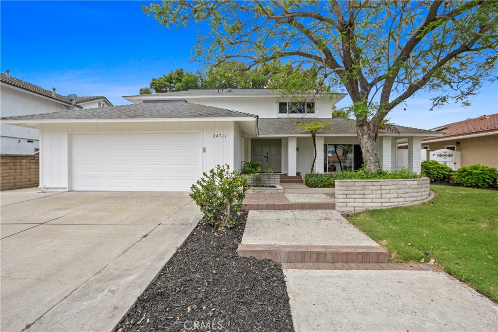 Reflecting today’s preferred aesthetic through an all-embracing and exquisitely crafted remodel, this generously sized home in Mission Viejo’s desirable Aegean Hills neighborhood is now a showplace for modern living and timeless design. Curb appeal is undeniable, with a classic white exterior, a covered entrance and graceful shade tree that create a welcoming scene. Double doors lead the way to a two-story interior that measures approximately 2,582 square feet. Five spacious bedrooms and three full baths cater to various lifestyles and multi-generational living, with a bedroom and full bath on the main floor. Entertain graciously in a formal living room with a large picture window and a formal dining room that opens to the backyard. Venetian plaster distinguishes the custom living room fireplace and another in the family room. Flowing freely to the family and formal rooms, the home’s reimagined open-concept kitchen is enhanced with waterfall-edge quartz countertops, a peninsula bar with seating, a wine refrigerator, soft-close wood Shaker cabinetry, open shelving, full tile backsplash and new stainless steel appliances. Two large sliders open the family and kitchen area to an ample backyard with mature trees, new landscaping and fencing, and a shaded patio space. Nearly 7,370 square feet, the homesite overlooks a neighborhood park. Baths are appointed with contemporary designer tile, upgraded vanities and mirrors, satin-finished brass plumbing and lighting fixtures, and in the secondary bathroom located upstairs, gorgeous marble flooring. Custom built-ins are showcased in the second floor’s open hallway, which leads to an inviting primary suite where a walk-in closet includes a custom built-in storage system, and the ensuite bath shines with gorgeous on-trend tile, marble finishes, a freestanding tub, dual-head walk-in shower and two sinks. Wide luxury vinyl plank flooring, lux carpet in bedrooms, ceiling fans, fresh exterior paint, a new energy-saving HVAC system, an interior laundry room and an attached two-car garage with epoxy floor and rafter storage are included. Residents of Aegean Hills enjoy a vibrant and established community with no HOA dues and a location in the heart of Mission Viejo. Highly acclaimed schools, shopping centers, parks, golf courses, freeways and tollways are close to home. This exceptional residence presents a rare opportunity to enjoy turnkey luxury and timeless style in one of Mission Viejo’s most sought-after neighborhoods!