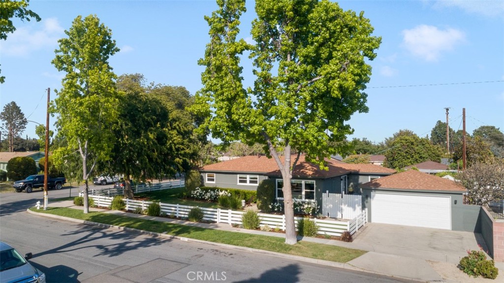 Welcome to this beautifully updated mid-century gem, built in 1952 and full of character! Nestled on a peaceful corner in the charming Park Santiago neighborhood—known for its tree-lined streets and vintage homes. This move-in ready residence blends classic design with modern updates in all the right ways. From the moment you arrive, the architectural details catch your eye: a sleek horizontal fence, a stylish wood-and-glass front door, fresh dark gray/green paint with crisp white trim, and newly added front steps and porch—all setting the tone for the contemporary touches inside. Step through the door and into an airy, open-concept layout designed for comfortable living and effortless entertaining. Warm original wood flooring flows throughout, complemented by all-white walls, recessed lighting, and French doors that open to a private backyard oasis. The spacious living room features custom built-in entertainment cabinetry and a view of the landscaped, fully fenced front yard. With windows on three sides, the dining area is bright and inviting—blurring the line between indoor and outdoor living. At the heart of the home is a beautifully appointed kitchen with a large island that seats four, perfect for gatherings and everyday life. Enjoy stainless steel appliances, a mix of butcher block and quartz countertops, glass-front cabinetry, and abundant natural light—making this space both functional and stylish. Outside, you’ll find two cozy patio areas, including one with a fire pit—ideal for relaxing under string lights on a warm evening. The detached 2-car garage includes new 6A electrical for car charging and a wide driveway for added convenience. This home offers three comfortable bedrooms and two tastefully updated bathrooms, including a private primary suite. The laundry room was remodeled with tile floors and a folding table with open shelves. The spacious, fully fenced front yard provides a secure play area or the perfect spot to unwind. With fresh interior and exterior paint, new insulation, an upgraded electrical panel, and newer HVAC, tankless water heater, plumbing, and roof systems, this home is not only beautiful but also thoughtfully maintained. All in all, this is a wonderful opportunity to own a stylish mid-century home in one of the area's most desirable, centrally located neighborhoods. Come see for yourself—you’ll feel right at home!