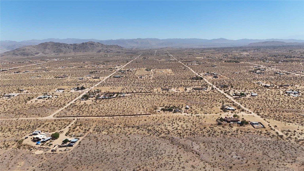 Two adjacent parcels totaling 5.09 acres just minutes from Joshua Tree National Park. Enjoy hiking, rock climbing, stargazing, hunting, fishing, off-roading, and local shops within 20–30 minutes. Zoned RL5 for site-built or manufactured homes with limited RV use. Well and septic needed; overhead electric nearby. Dirt road access, 3,330 ft elevation, no HOA, and not in a flood zone. See the property in person to appreciate its potential.