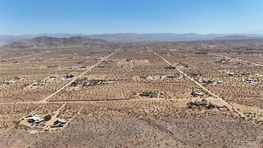 Two adjacent parcels totaling 5.09 acres just minutes from Joshua Tree National Park. Enjoy hiking, rock climbing, stargazing, hunting, fishing, off-roading, and local shops within 20–30 minutes. Zoned RL5 for site-built or manufactured homes with limited RV use. Well and septic needed; overhead electric nearby. Dirt road access, 3,330 ft elevation, no HOA, and not in a flood zone. See the property in person to appreciate its potential.