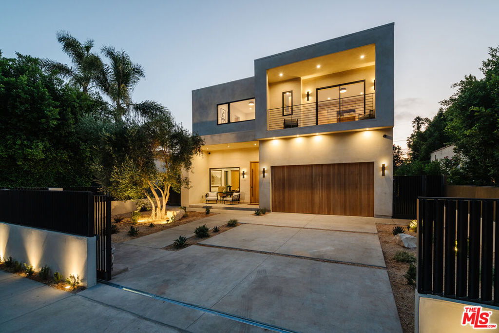 Presenting this exceptional 2023 custom new construction a 5-bedroom, 5.5-bathroom smart home with rooftop that blends refined luxury with modern functionality. From the moment you step through the custom oak entry door, you're greeted by a fully automated Control4 smart system that tailors lighting, sound, and climate to your preferences, setting the tone for effortless living in this solar-powered sanctuary. The main level is centered around a striking Great Room featuring an illuminated wine wall and 16-foot retractable glass pocket doors that dissolve the boundary between indoor and outdoor living. The doors open to a stunning KAYU Golden Balau hardwood deck, seamlessly connecting the interiors to a vibrant backyard oasis. At the heart of the home, the chef's kitchen stuns with Shinnoki Milk Oak cabinetry and sleek porcelain travertine countertops and island, complemented by a premium built-in Wolf stovetop. A unique pass-through window opens directly to the backyard for easy entertaining. The backyard is a resort-style retreat with a heated pool and jet spa, both controlled by an automated system with customizable lighting and temperature settings. New upgrades include a sauna, cold plunge, and an outdoor dining area perfect for unwinding in total luxury. Ascend the floating staircase bathed in natural light from oversized picture windows and a skylight to discover four spacious ensuite bedrooms, each featuring custom floor-to-ceiling cabinetry and wide-plank European white oak flooring. The primary suite is a true sanctuary, with a custom limewashed accent wall, a private balcony overlooking the backyard, and a serene open-air lounge area. The suite also includes a cozy linear fireplace, a built-in wet bar with Shinnoki Milk Oak cabinetry, and a walk-in closet with LED-lit, custom shelving and cabinetry. The spa-like primary bathroom is dressed in full-slab stone tile and features dual vanities, dual shower heads, a freestanding soaking tub, and a smart toilet with bidet.Additional highlights include a state-of-the-art media room with 7.1 surround sound, a professionally installed security system, a rooftop entertaining area spanning approximately 800 square feet with a built-in grill and fire pit, and sweeping views of the Hollywood Hills that glow golden at sunset. The finished garage is complete with an EV charger and brand-new epoxy floors, ensuring every detail of this property is as functional as it is beautiful. This one-of-a-kind home was designed for elevated living, seamlessly combining organic materials, innovative design, and high-end features in every corner. An extraordinary offering one of the best walkable areas in Los Angeles.