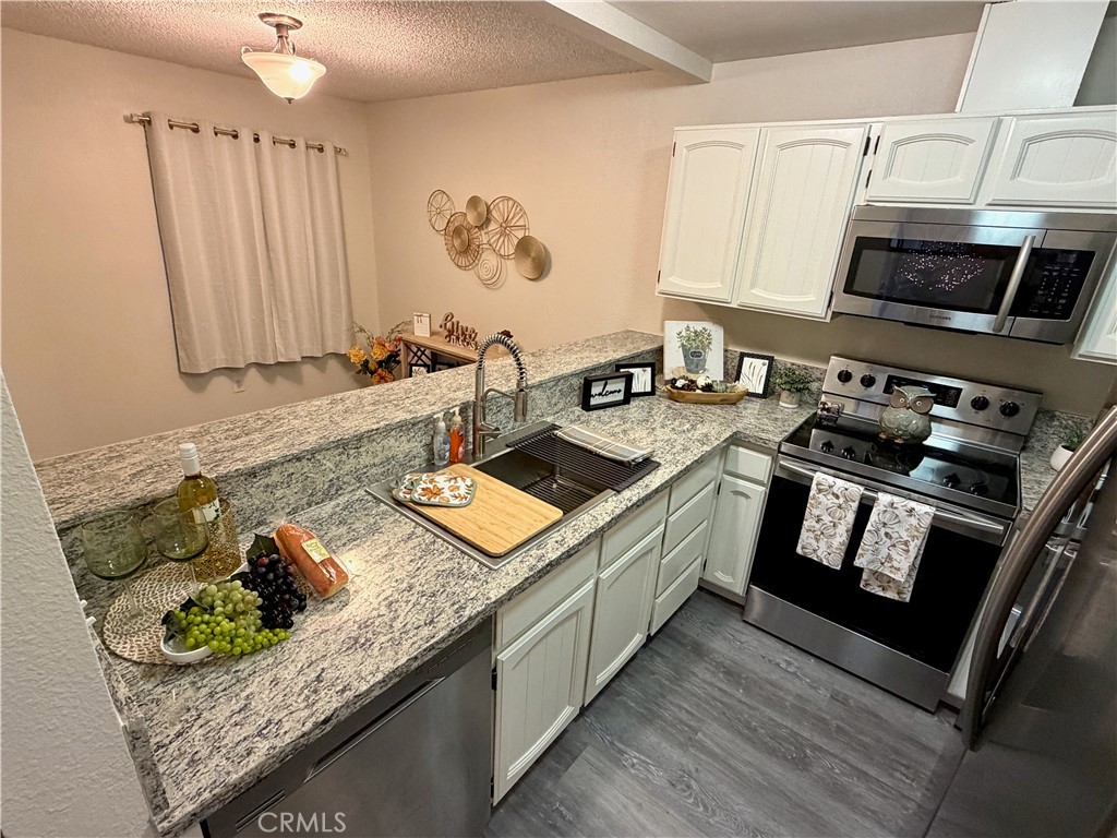 FHA/VA buyers - This complex is approved as a Planned unit Development property and accepts FHA loans! Welcome to this beautifully updated, move-in-ready lower-level condo featuring 2 spacious bedrooms and 2 bathrooms. Recent upgrades include laminate flooring, granite countertops, modern sinks, and fresh interior paint. The inviting floor plan offers a stylish kitchen with stainless steel appliances and a private covered patio perfect for morning coffee or evening relaxation. Located just a short walk from the pool and recreation areas, this desirable gated community provides resort-style amenities including a clubhouse, exercise room, pool, spa, and tennis courts. Water and garbage utilities are included for added convenience. With proximity to parks, schools, shopping, and quick freeway access to HWY 99, this condo combines comfort, style, and convenience Home couldn't feel better! Schedule a showing before it's too late