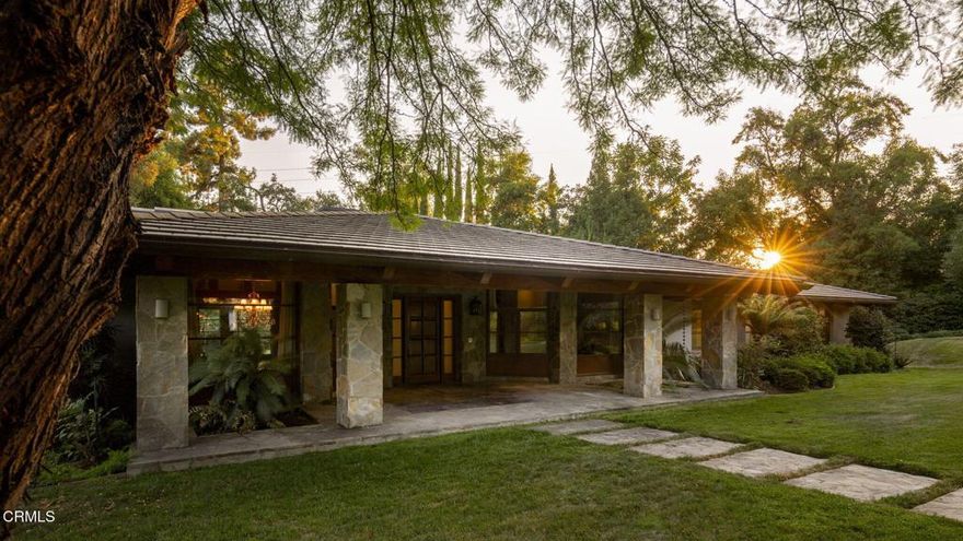 First time on the market, this architectural gem in Pasadena's prestigious Chapman Woods neighborhood offers timeless craftsmanship, generous scale, and serene surroundings. Designed by renowned architect Don Lee and custom built in 2005, the single-story residence spans 6,113 square feet on a lush 37,905-square-foot lot.Set behind an expansive front yard, the home's commanding stone porch welcomes you into a foyer that opens to formal living and family rooms, each overlooking the tranquil backyard. A long, light-filled hallway with soaring ceilings and multiple skylights creates a stunning central axis for the home. Throughout, vaulted ceilings, dramatic floor-to-ceiling windows, and exquisite details--including custom copper gutters and Japanese-imported rain chains--reflect the quality of design and construction.The thoughtful floor plan includes five spacious bedrooms and seven bathrooms, with each bedroom enjoying its own ensuite. Two primary suites, each overlooking private zen gardens, create retreat-like sanctuaries. Additional spaces include a dedicated craft room, office, wine closet, and formal dining room. The open-concept kitchen and adjoining family room make the home ideal for entertaining, while the formal living room--with its grand fireplace--adds timeless elegance.Outdoors, a large covered patio overlooks a waterfall and koi pond, creating a serene backdrop for gatherings. A four-car garage, expansive front lawn, and mature landscaping complete this rare offering.A statement of refined living in Chapman Woods, this estate blends architectural pedigree with warmth, comfort, and enduring quality.
