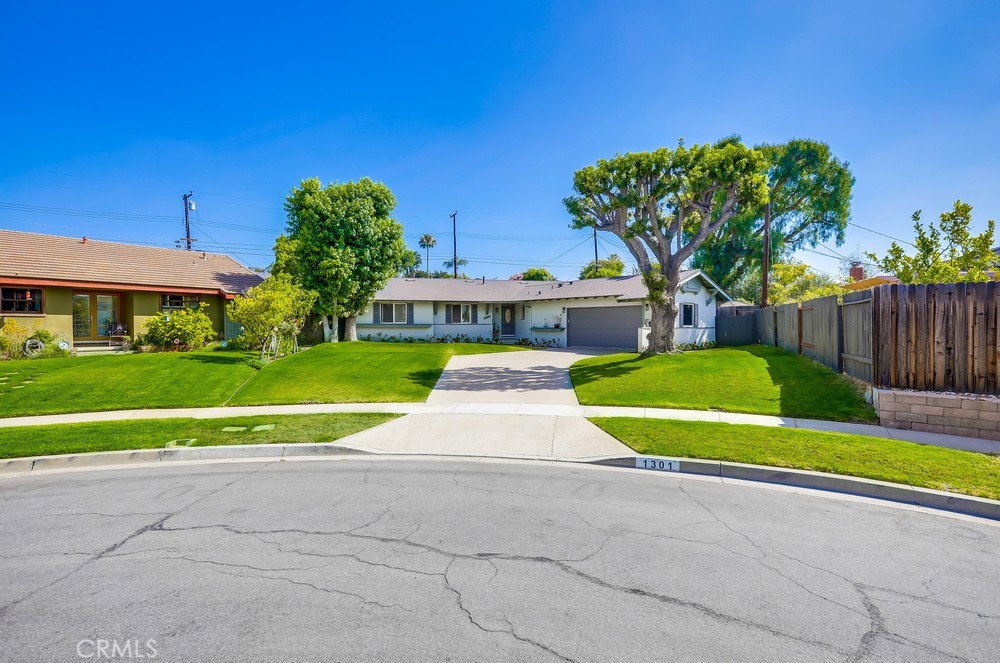 Welcome to 1301 Cameo Dr., a delightful single-level home nestled on a quiet cul-de-sac in the heart of Tustin. This four-bedroom, two-bath residence sits on an expansive lot, offering both comfort and potential. The bright and airy living room features skylights that bathe the space in natural light, creating a warm and welcoming atmosphere. Step outside to a spacious backyard patio—ideal for outdoor dining, entertaining, or simply soaking up the California sunshine. The large backyard is a true blank canvas, ready for your personal touch—whether you envision a lush garden, sparkling pool, or private outdoor retreat. A wide driveway offers ample parking, adding everyday convenience. Centrally located near top-rated schools, shopping, dining, and major freeways, this home combines tranquility with accessibility. Don’t miss your chance to make it your own!