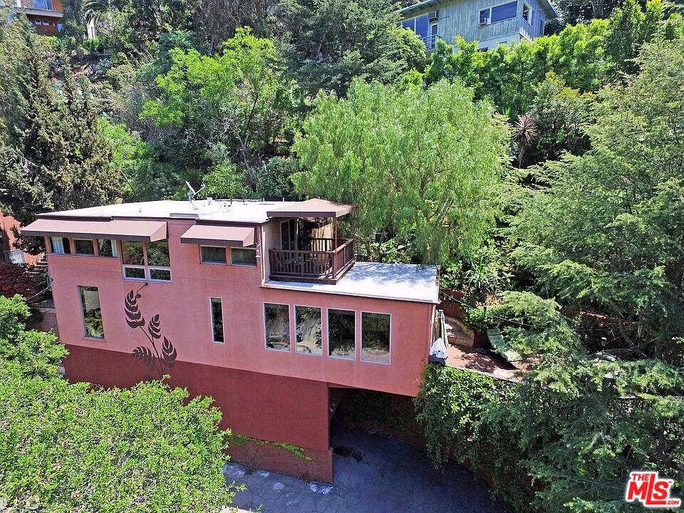 A Gorgeous Laurel Canyon Hillside Home with so many incredible features! Located 1/4 mile from the famous Laurel Canyon Market and Pace "Pa - Che" ( The Famous Laurel Canyon Italian Restaurant) this home is one of the few hillside homes that sits on are relatively flat street which is amazing for walking. A wonderfully spacious parking area can accommodate SIX (6) cars. There are two carports with tons of storage!, one space has an EV charger and there's parking next to the house and on the driveway. A quick flight of stairs leads to the formal entry with a bedroom/office just off the entry. Wood floors throughout the living spaces and tile throughout the bathrooms and kitchen creates a warm midcentury vibe. Enjoy a 600sf wood deck right off the living room that is great for BQQing lounging under the shade of a mature tree canopy. The owners had labor day weekend party and the flow from the kitchen through the living room to the outdoor deck was just smooth and natural. The upstairs has two large on-suite bedrooms separated by a laundry bay. One bedroom has a large walk in closet, dual sinks in the bathroom, a jacuzzi tub and walk in luxury shower. The second upstairs bathroom has a great sized south facing balcony and is about double the size of a normal bedroom. This home has been occupied by the owner for 6 years and is being leased for the first time. Schedule a showing today to experience the beauty of Laurel Canyon.