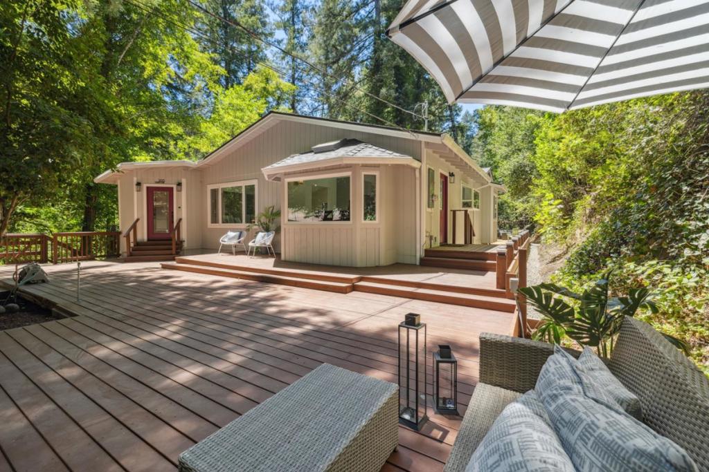 Modern Creekside Retreat. Tucked at the end of a quiet lane, two-story 'Smart' home offers the perfect blend of privacy, luxury, and natural beauty. Situated on just over half an acre, this 2,133 sq ft residence features 4 spacious bedrooms and 3 bathrooms, ideal for families, remote workers, or anyone seeking space to breathe and unwind. Step inside to discover vaulted ceilings and abundant skylights that flood the home with natural light. The gourmet kitchen is a chefs dream, featuring sleek quartz countertops, custom cabinetry, and a suite of new stainless steel smart appliances. A dedicated laundry room with a brand-new stackable washer and dryer adds day to day convenience. Every detail has been thoughtfully chosen for both beauty and functionality. The heart of the home extends outdoors to an expansive 1,525 sq ft redwood deck, a rare gem perched above the year-round Bear Creek. Whether you're sipping your morning coffee or hosting evening gatherings, this serene backdrop delivers peace and privacy. All just minutes from downtown Boulder Creek, yet worlds away in its tranquil, wooded setting.. (A smart home is equipped with devices that can be remotely monitored and controlled.) End-of-the-road privacy. A modern sanctuary in the redwoods.