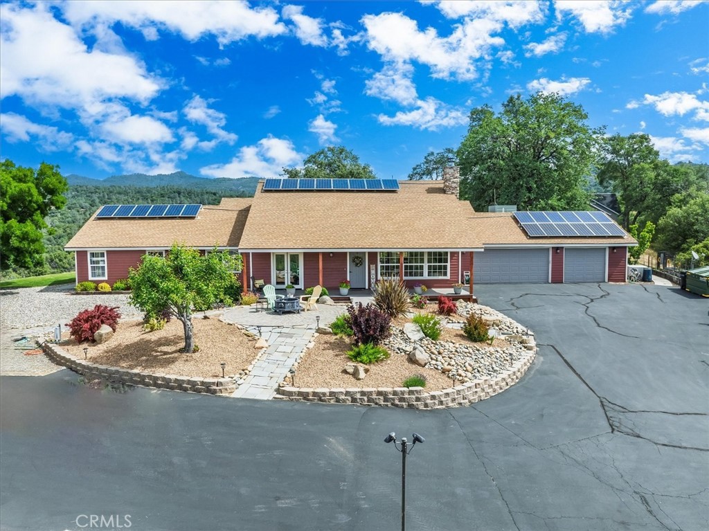 Live above the smog, and valley heat, on 2+ acres, with amazing 270 degree views! This spacious one story home features 2501 sqft of living space with 4 beds, 3 baths, custom built ranch style home located in the Miami Highlands neighborhood, of Oakhurst California. Featuring vaulted ceilings, updated kitchen, with a large island, reverse osmosis water system, built in desk, & new tile floors. The home boasts a beautiful rock fire place with an open concept to the kitchen, dinning area & living space. Each bedroom features large closet space with ample storage, the primary bedroom has a large walk in closet, with a remodeled bathroom featuring a lovely fireplace/heater and is great for ambiance, while enjoying your oversized jetted tub. Primary bedroom, there is a patio right outside the sliding glass doors, perfect to watch the gorgeous sunsets this home witnesses almost daily. The home features a grand laundry room with butcher block countertops, a deep utility sink, & lots of storage. The home was upgraded with an energy efficient air conditioning system and heating, while the old HVAC ducting was rerouted to cool the garage only. The garage is oversized making it a dream to do daily projects or provide more storage. This home also has an OWNED 6,000 watt solar system with a 26,880 watt lithium battery back up power system. There are dual pane vinyl windows throughout, and beautiful bamboo wood floors. Walking out the front door you will notice the gorgeous covered porch, with new trex deck, and a nicely landscaped yard with above ground fire pit and nighttime lighting that leads to the street. This home has also been freshly painted inside and out, and is in pristine condition! Did we mention the array of fruit trees, the vegetable garden, and two sheds? The fruit trees will be listed with all the amenities this home offers, ask your agent for the list, you won’t be disappointed! Call for a private viewing of this gorgeous home located just about 1/2 hours drive from Yosemite National Park. We can’t wait to show you around.