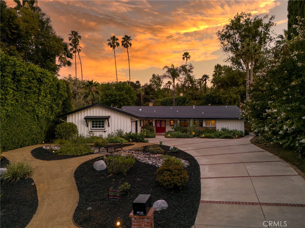 Welcome to Your Private Resort in Woodland Hills! Nestled on a spacious half-acre lot, this beautifully upgraded four-bedroom, four-bathroom home offers the perfect blend of comfort, style, and functionality—ideal for both family living and entertaining. Set back from the street, the property boasts a long driveway and eye-catching drought-tolerant landscaping, creating a serene and inviting entrance. Step inside to find hardwood flooring throughout the living and dining areas, complemented by a stone fireplace that anchors the open floor plan. The heart of the home is a spacious island kitchen with a sunny breakfast nook, seamlessly connected to a formal dining room, expansive living room, and a separate family room—easily convertible into an additional guest bedroom. Large patio doors open to your own backyard oasis: an entertainer’s dream featuring a sparkling pool, generous patio space, lush grassy areas, a charming playhouse, and a raised bandstand area perfect for events or relaxation. The stunning landscaping adds a tranquil, resort-like atmosphere. Additional highlights include fresh paint and new carpet in the secondary bedrooms, spacious laundry room, direct access two-car garage and separate guest room/office with an attached half bath and private patio with a fountain. Whether you're hosting a gathering or enjoying a peaceful day at home, this Woodland Hills gem offers it all. Come experience the lifestyle you’ve been dreaming of!