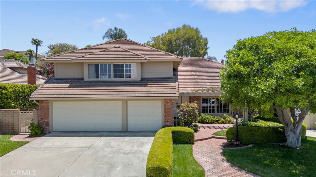 Located in the desirable Spy Glass Estates, this large turnkey home offers over 3,200 square feet of airy, sun-filled living space. From the charming front porch sitting area to the sweeping spiral staircase, style and comfort meet at every turn. Soaring vaulted ceilings, Italian tile flooring, a wet bar, 2 fireplaces, and seamless indoor-outdoor flow make this home ideal to enjoy with family and for entertaining with friends. The remodeled kitchen features a center island, ample counter space and stainless steel appliances. There is a main floor bedroom and bathroom with a gorgeous new shower. The primary suite is a true retreat with a sunken tub, shower, double vanity, and large closet. The oversized upstairs family room offers endless possibilities—office, playroom, media room or even a potential fifth bedroom. The lush front and back yard was professionally curated by R.A. Landscape Designers. The back is exquisitely manicured and very peaceful. There are multiple fruit trees including avocado and lemon, along with a large shaded patio and a serene pond. Other features include an indoor laundry room with a utility sink along with a 3 car garage. Tucked in a beautifully maintained neighborhood close to schools, shops and local favorites, this home offers the perfect blend of tranquility and convenience.