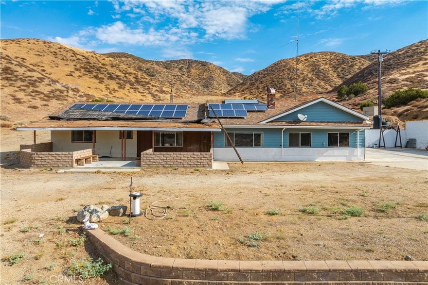 Fixer-Upper with Acreage in Leona Valley! Opportunity knocks with this nearly 5 acre property tucked away in the picturesque setting of Leona Valley. Built in 1973 this single-story home offers almost 1700 sq. ft. of living space and plenty of room to make it your own. The home features 3 bedrooms, 2 bathrooms, a spacious living room with a pellet stove, and an additional front room located just off the dining area that could serve as a den, office, or playroom. The kitchen connects conveniently to the indoor laundry area, which also provides direct access to the attached spacious, oversized garage featuring two sectional doors, including one extra-tall door perfect for accommodating larger vehicles, smaller RVs, or workshop equipment. The generous interior provides ample space for storage, projects, or hobbies, making it both functional and versatile. While the property is in need of updating and repairs, the floor plan provides a solid foundation for your renovation vision. Outside, the acreage offers sweeping views of the surrounding hillsides and plenty of usable space for animals, gardening, or outdoor projects. Two outbuildings add to the appeal: A durable metal shed ideal for tools, equipment, or extra storage. A charming faux ''old-time country store/gas station'' style building. With its nostalgic character, it's currently used as storage but could easily serve as a whimsical playhouse, hobby space, or creative studio. This is truly a fixer-upper with endless potential. Whether you're seeking a full-time country residence, a weekend retreat, or an investment opportunity, the setting provides the peace and privacy of rural living while still being within a short drive of city conveniences. With nearly 5 acres at your disposal, the possibilities are as wide open as the valley views. Bring your imagination, roll up your sleeves, and create the country lifestyle you've been dreaming of!