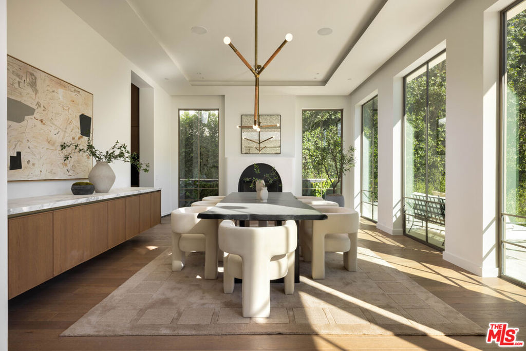 This stunning new construction residence is a masterpiece of luxury and design, featuring an impressive array of amenities crafted for both relaxation and entertainment. Step inside to a chef's kitchen with custom marble countertops, Miele appliances, and Italian-made Pedini cabinetry, flowing into living spaces framed by a unique custom-curved staircase, elegant wood paneling, and a living garden wall. A dedicated wellness center includes a cedar wood dry sauna and marble steam room, while a private movie theater offers in-home cinematic experiences. Natural light pours in from an architecturally designed central skylight, highlighting the open layout and custom glass front pivot door. The expansive rooftop deck, complete with an exterior fire pit and outdoor kitchen, along with a large pool, jacuzzi, and spacious backyard lawn, provides a resort-like atmosphere for outdoor living. Additional features like a convenient elevator, spacious 4-car garage, and beautifully landscaped surroundings complete this unparalleled new construction residence, designed to elevate modern luxury living.