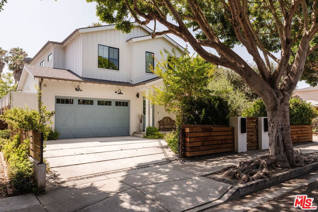 Discreetly positioned behind gates in the coveted Ocean Park neighborhood of Santa Monica, this Traditional-style home was built by Pillar Homes in 2019 and unfolds with quiet, sophisticated confidence. White clapboard siding and a robin's egg blue front door offer the first hint at the home's personality -- timeless and thoughtfully curated. Inside, wide-plank oak floors stretch beneath crisp millwork, designer wallpaper, and premium finishes, while radiant natural light illuminates every space. The living room centers on a charcoal-toned stone fireplace and seamlessly opens to lush garden views. The kitchen is as stylish as it is functional, showcasing a marble-topped center island with seating, custom cabinetry, and premium appliances including a JennAir double oven range with a pot filler, SubZero refrigerator, and Miele dishwasher. Just beyond, a bright dining area with access to an al fresco dining patio is ideal for entertaining. The backyard is surrounded by mature privacy hedging and outfitted to enjoy warm California days and cool nights underneath the stars. Here, discover a versatile plunge pool or spa, multiple lounge areas, and a turf lawn. The home features five ensuite bedrooms with one on the main level and four upstairs. The primary presents a serene retreat set beneath high, vaulted ceilings with a walk-in closet and ensuite bathroom that feels quietly indulgent -- complete with dual vanities, a soaking tub, and a rainfall shower. Other notable features include surround sound speakers throughout, a state-of-the-art Wifi system, a convenient powder bath, custom window coverings, and an attached 2-car garage with HVAC and polished concrete floors. Supremely located in Santa Monica, only 1-mile from the beach and just moments from Penmar Golf Course, Marine Park with tennis courts, popular restaurants, and boutiques, this Ocean Park home is the ideal setting to realize your dream Westside lifestyle.