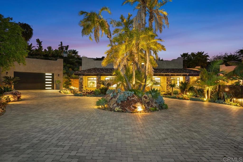 Luxury, comfort, and refinement come together to showcase this magnificent multi-generational estate into an entertainer’s oasis! Enviably set in the prestigious Encinitas Enclave community, this custom-designed residence welcomes you with a gated, paved driveway bordered by towering palms and impressive landscaping. Built in 2021 on an expansive lot, this ultra-private 5-bedroom, 4.5-bathroom custom home delivers nearly 5,000 SF of refined living conceived for comfort, calm, and everyday luxury. Inspired by timeless hacienda elements and finished with sleek modern touches in every corner, a layout crafted for both elegant and enhances any celebration under the sun or stars. Mature palms and sculpted landscaping frame the mandala-shaped driveway, guiding you to a shaded veranda with cut stone columns. Inside, natural light pours through multiple skylights, illuminating crisp white tones, modish finishes, and wide-plank wood floors. An open layout connects the living, dining, and kitchen areas under a vaulted barrel ceiling, anchored by an impressive stone fireplace—ideal for relaxed evenings in or hosting weekend festivities. The kitchen is a culinary showpiece, outfitted with top-tier stainless steel appliances, a waterfall-edge island with designer lighting, custom cabinetry, and a walk-in pantry featuring a beverage center and appliance station. Glass bi-fold doors leading to the outdoor living, a resort-style sanctuary. A personal oasis, this generous courtyard serves as the hub of activity, featuring a new pool with soothing water features and a jacuzzi surrounded by vibrant foliage, a built-in grill, bar seating, and a fire pit for al fresco gatherings or unwinding under the stars. Two outdoor showers offer a spa-like retreat and a refreshing rinse after a swim or beach trip. The clubhouse expands your entertaining possibilities with its wet bar/kitchenette, full bath with sauna, and bi-fold doors that open to the courtyard—ideal for a remote office, gym, studio, or additional accommodations. The clubhouse can also be served as a 2nd ADU. The thoughtfully designed floor plan supports multigenerational life. Your primary suite features its own sculpted stone fireplace, expansive walk-in closet, and spa-inspired ensuite with a soaking tub, oversized glass shower, and direct outdoor access. Two more bedchambers in the main building are joined by a shared washroom. A versatile, detached 488 SF guesthouse includes a separate bedroom, full kitchen, and its own lavatory—ideal for overnight visitors or as an ADU. Prepped for a privacy gate and devised for a lock-and-go lifestyle, this residence combines low-maintenance landscaping with thoughtful features throughout. Just minutes from top-rated schools, local beaches, El Camino Promenade, and San Dieguito Tennis Club, it offers a rare blend of seclusion and convenience. If you're ready to experience the best of coastal luxury without compromise, this home is the one for you!