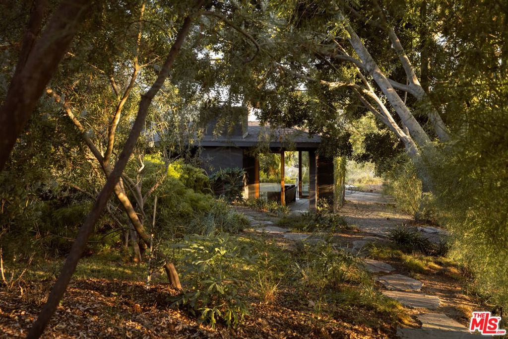 Tucked away on over an acre in Pasadena's Annandale Estates, this restored and updated mid-century home offers a rare combination of architectural pedigree, thoughtful design, and modern livability. Originally built in 1953 by noted architect James DeLong, a protege of Frank Lloyd Wright, the home has been carefully renovated to preserve its original character while introducing high-end, contemporary finishes. The main residence features three bedrooms and two bathrooms, an open-concept kitchen, and a sunken living room. Walls of windows along with clean, natural materials wood, stone, and concrete create a bright, tranquil, and cohesive space that connects seamlessly to the outdoors. The landscape, designed by Terremoto, enhances the property's sense of privacy and connection to nature. A garden path leads to a separate pool area with a pool house, fireplace, and an outdoor shower, offering a quiet space for relaxing or entertaining. This home balances mid-century architecture with modern functionality ideal for buyers looking for a private, design-forward property in a sought-after Pasadena location.