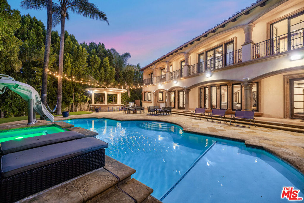 Fully furnished and equipped, this estate is available for long and short-term rentals. It features 7 bedrooms and 8 bathrooms. Located at the end of a quiet cul-de-sac, it's within a short distance of Ventura Blvd. The property boasts a large, open floor plan with high ceilings, a theater room, office space, and a fully equipped kitchen. The expansive master bedroom offers a sitting area, custom walk-in closets, and an en-suite bathroom with dual sinks, a vanity, a walk-in shower, and a separate soaking tub. The vast backyard includes a large pool with a slide, a Jacuzzi, and a playset.