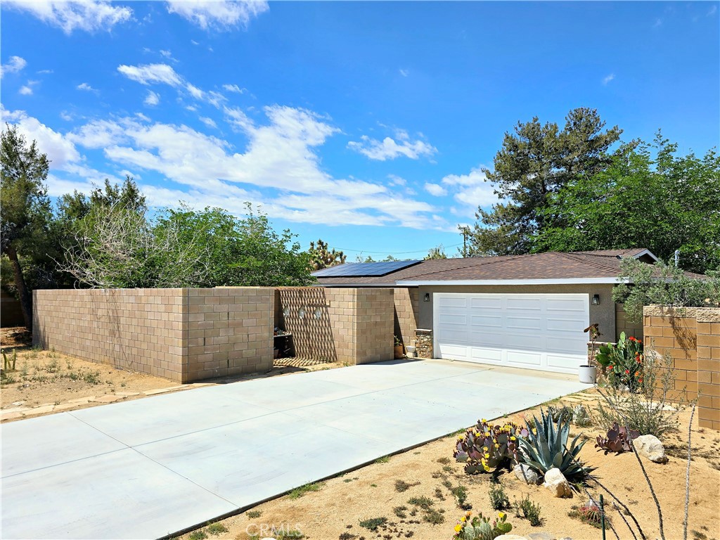 Welcome to your tranquil retreat in this beautifully appointed modern home, where Serene Solitude awaits. The front courtyard, designed with a craftsman-style block wall and elegant glass inserts, offers an inviting entryway while ensuring both privacy and serenity.
Step inside to discover a fully updated interior that blends style and functionality. The extra-large living room is both inviting and luxurious, featuring a designer-friendly electric fireplace with multiple settings for warmth and ambiance. This space seamlessly connects to the kitchen and dining area, creating an ideal layout for entertaining or everyday living.
The kitchen is a standout, boasting a unique and sturdy epoxy-covered cement countertop that is not only practical but also serves as a stunning centerpiece. A vibrant tile backsplash adds a delightful splash of color and texture, enhancing the contemporary feel. Throughout the home, stylish LVP flooring provides a cohesive flow from the living area into the kitchen and bedrooms, offering a low-maintenance option with no carpet in sight.
The spacious main bedroom is a true sanctuary, complete with two closets and a well-appointed ensuite featuring double sinks set atop an exquisite epoxy-covered cement counter. You'll also appreciate the generous use of tasteful tile throughout the home, particularly in the bathrooms.
Two additional guest bedrooms offer ample space and thoughtful decor, ensuring comfort for family and friends. The conveniently located indoor laundry room is impressively large, making chores a breeze.
Venture outside to the covered patio, perfect for relaxation or entertaining. The outdoor space features an outdoor shower, a chicken coop for fresh eggs and a divided area for horses, catering to those with a passion for country living. Enhance your well being by using the meditation cave. Custom gates add an extra layer of privacy and convenience to this enviable property.
Don't miss the opportunity to call this custom home in Northern Yucca Valley your own. Experience the perfect blend of modern comfort and serene living!