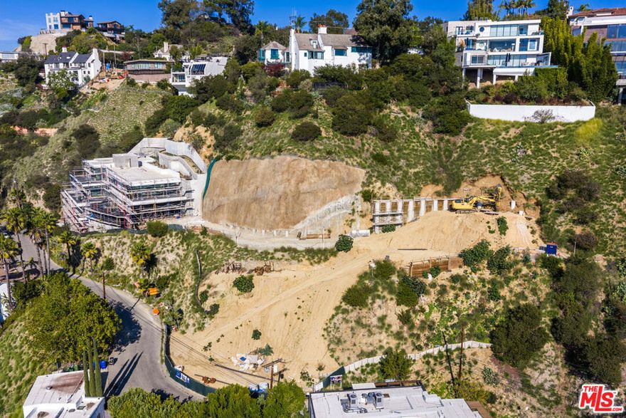 This exceptional offering is the sister property to 2034 Sunset Plaza, positioned directly next door and designed with the same world-class vision. Encompassing approximately 11,000 square feet and soon to be listed at $25 million, the site offers buyers a rare chance to preview its nearly completed counterpart at 2034 Sunset Plaza to fully understand the scale, design, and end result this property will deliver. What makes this opportunity especially valuable is that extensive foundation and preparatory work has already been executed (by DJ Sheffler - one of the top foundation contractors in the industry) - significantly de-risking the project for a future buyer. Ground has been broken, property has been cleared of debris, rough-graded, and improved with temporary access roads to ensure safe movement of heavy equipment. Staging areas and solid work platforms were established to support the machinery required for installing the deep foundations - including 34 piles per drilling shafts aprx 80' deep - handling and relocating spoils, fabricating and placing rebar, and setting concrete, along with multiple crane and pump configurations used throughout construction. Temporary lagging has also been installed to secure access points and safely lower the grade level of the site, ensuring the project can resume seamlessly. The entire hillside has been fully shotcreted with extensive soil nailing, and the major slope cuts are already complete. The site features an additional lower entrance, an unusually large flat motor court that can accommodate up to eight cars - a rarity in the Hollywood Hills,  plus a secondary motor court at the top. The property also captures a stronger view corridor than its sister home currently nearing completion, offering elevated sightlines and exceptional privacy. A truly rare, advanced-stage development opportunity with RTI plans by notable IR Architects in one of the most coveted view corridors in Los Angeles