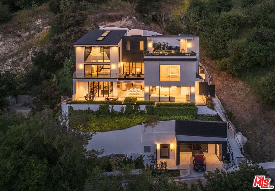 Live Above It All. A Trophy Estate of Uncompromising Luxury Perched high on one of Sherman Oaks' most prestigious and private streets south of Ventura Boulevard, this newly constructed gated estate is the ultimate embodiment of modern luxury, architectural excellence, and refined California living. Completed in 2023, this bold and visionary residence spans nearly 8,000 square feet, offering an exceptional blend of form, function, and flawless design. At once an entertainer's dream and a serene retreat, it exudes a rare level of craftsmanship and scale that few homes can match. Inside, 4 expansive bedrooms and 8 meticulously appointed bathrooms offer comfort with sophisticated detailing throughout. The crown jewel of the home is the dramatic two-story primary suite, encased in floor-to-ceiling glass that opens to sweeping canyon vistas. This palatial space is framed by dual spa-like en-suite bathrooms, oversized boutique-style walk-in closets, and a sense of grandeur that rivals the most elite penthouses. From the moment you enter this estate you're met with intention and impact, dramatic foyer with a tranquil water feature, a dedicated guard room for added security, and a private elevator that seamlessly connects each level. Throughout the home, walls of glass, soaring ceilings, and gallery-like volumes invite natural light to cascade across curated finishes, creating a powerful sense of openness and fluidity. The lower level is designed for unforgettable moments, featuring a full-scale private theater perfect for movie nights or game-day gatherings. Outside, the home becomes a resort unto itself boasting a massive pool and spa, multiple lounge areas, and an expansive entertainer's terrace overlooking the rolling hills and sparkling city lights beyond. Ideally located just minutes from Ventura Boulevard's finest dining, boutiques, and hiking trails, this estate combines seclusion with accessibility. It's more than just a place to live it's a statement. A lifestyle defined by bold beauty, effortless sophistication, and the freedom to live without compromise.