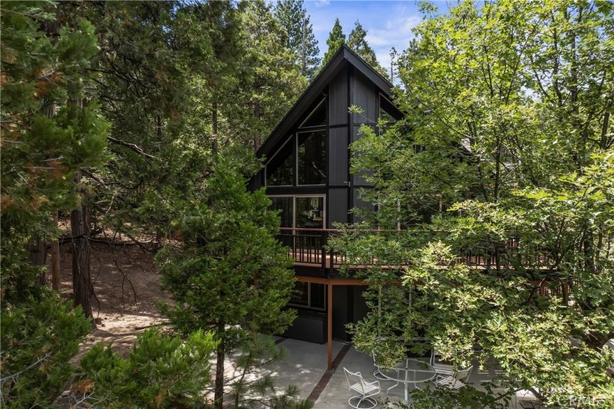 Phenomenal Prow Style home located directly across from the forest and trails, with easy access to the golf course just down the street. This property also includes Lake Rights, allowing full use of beautiful Lake Arrowhead. Over $300,000 in upgrades, including a recently remodeled kitchen with high-end professional-style appliances, slab quartz countertops, and a garden bay window overlooking mature evergreens and oaks on your own land. The home features 4 bedrooms, 3 bathrooms, an office, and a den/family room with a second fireplace—ideal for gatherings or quiet relaxation. The main-level “Great Room” highlights natural wood open-beamed ceilings and a classic “retro rock” fireplace that adds warmth and character. Additional updates include remodeled bathrooms, new interior and exterior paint, newer lower patio/deck, fenced yard, upgraded flooring, newer forced air system, "Leaf Guard Style" rain gutters and system improvements. Both the new Flagship whole house water filtration system and an additional Revrse Osmosis system at the sink ensure the best of the best for your water supply. Both guys and gals can relax in the "She-Shed" while the guys have their own storage shed, too. Located in a peaceful, forested setting with nearby recreation and golf access, this home offers both comfort and convenience in one of Lake Arrowhead’s most desirable areas.