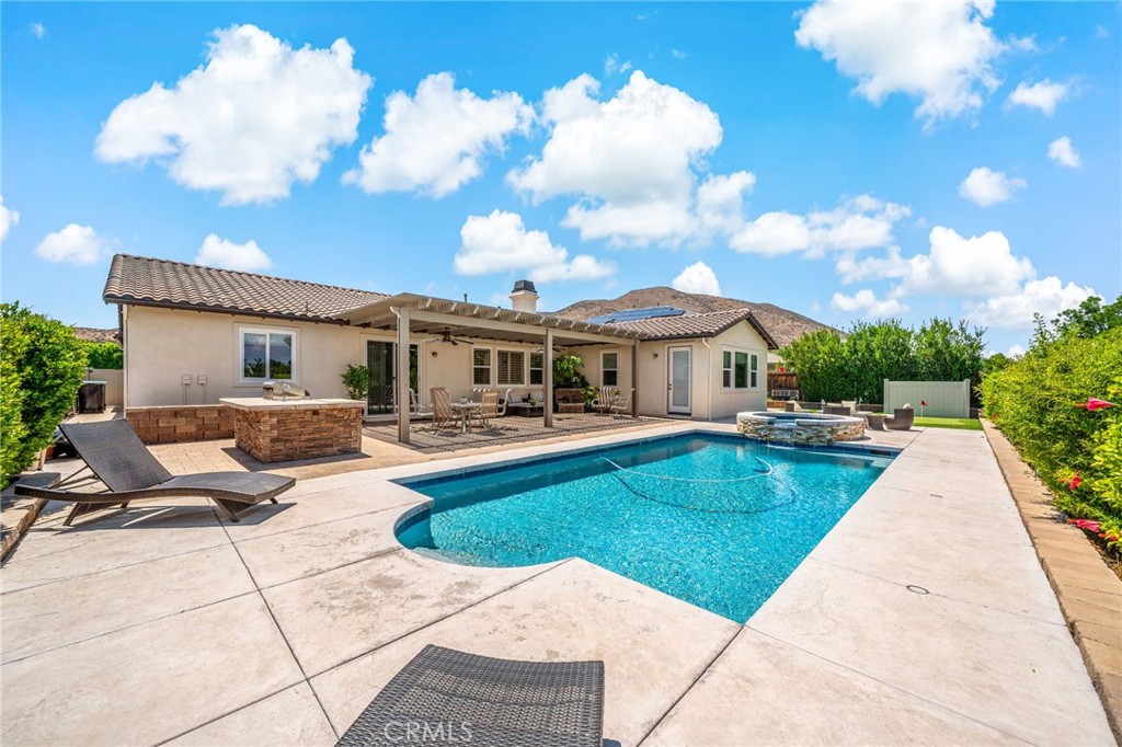 SHOWSTOPPING SINGLE-STORY POOL, CUL DE SAC HOME WITH OWNED SOLAR IN HIGHLY SOUGHT AFTER HERITAGE LAKE COMMUNITY– NO REAR NEIGHBORS, AND LOADED WITH UPGRADES!!! This meticulously upgraded 4 bed, 2.5 bath Menifee gem checks all the boxes — with a premium cul-de-sac lot, owned solar, all new windows, and 10-foot ceilings throughout! Step inside to a bright, open floor plan that’s been enhanced with new LED lighting, shutters, and a whole-home water purification system. The heart of the home flows effortlessly between the cozy living area with fireplace and a kitchen designed for entertaining — complete with generous counter space, plenty of sleek cabinetry, an island with seating, stainless steel appliances, and an adjacent dining area. The primary bedroom is a true retreat with large, gorgeous windows to take in the views, an ensuite bathroom with soaking tub, standing shower, dual vanities, and walk-in closet, and direct access to the private backyard! Relax in the sparkling pool and spa, fire up the built-in BBQ, or take a swing on the personal putting green — all while enjoying the privacy of no rear neighbors and low-maintenance landscaping with artificial turf and a drip irrigation system. This one has it all with single-story convenience, luxury upgrades, energy efficiency, and a dream backyard built to impress, all set in the amenity-rich Heritage Lake community which includes 2 Jr. Olympic size pools, Splash Park, a wading pool, 3 tot-lot playgrounds, paddle boats to explore the 25-acre lake, catch-and-release fishing! All that and just minutes from top schools, shopping, and entertainment – this home is an absolute CAN’T MISS!