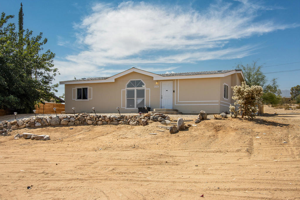 Panoramic views! Beautiful 3 bed 2 bath home in the sought after hillside section of the JT village, plus a large detached garage and fenced backyard on almost a quarter acre corner lot. Front door opens to the living room with vaulted ceilings and over sized bay window. Kitchen features a breakfast bar, stainless steel refrigerator, stove and dishwasher, long counters and ample cupboards. Master bedroom with private bath and walk in closet. Two other large bedrooms are located at the other end of the living room. Enclosed backyard offers privacy and wonderful open sky views. The detached two car garage is conveniently located at directly off the paved road. With this central location you are a short bike ride and drive to organic food, cafes, restaurants, boutiques and some of the nicest outdoor trails in the country. Nearby Sportsman Park offers tennis courts, basketball courts, baseball diamond, playground, dog park and shaded picnic tables. Just under 5 miles to the Joshua Tree National Monument where about 3 million tourists visit annually. 40 miles to Palm Springs. 128 miles to Los Angeles. This would be a wonderful full time residence, investment, and rental. Don't wait on this one - schedule a viewing today!